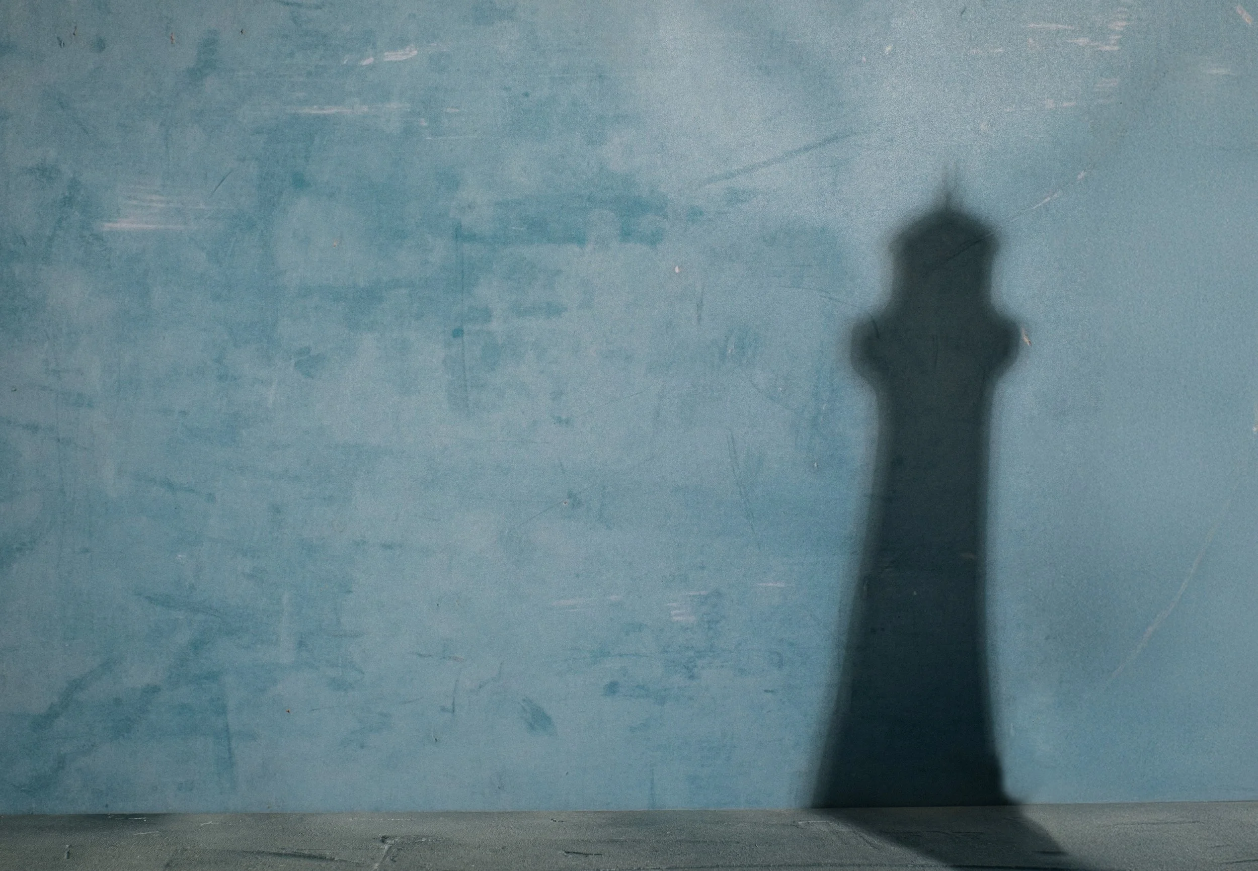 Shadow of a lighthouse on a blue background