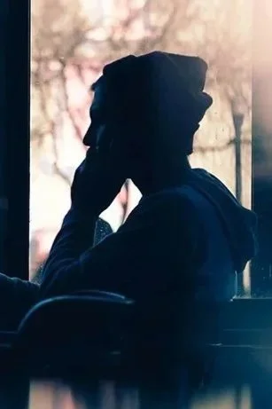 Silhouette man near window