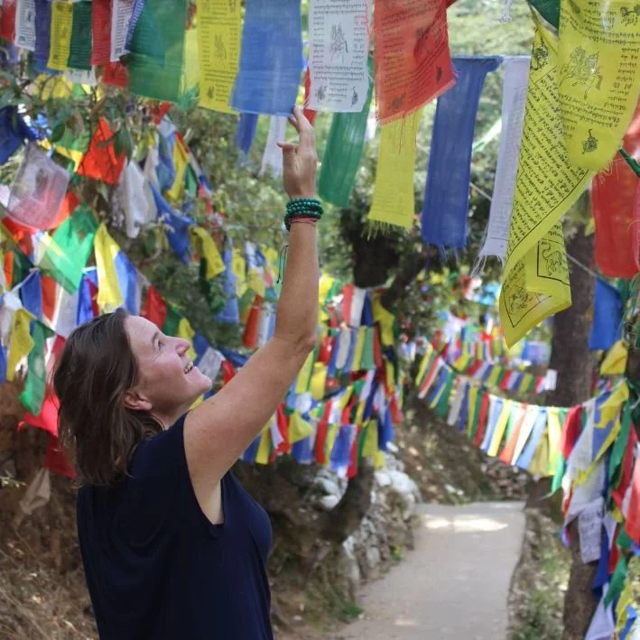 Karin Peeters amidst Buddhist prayer flags in Dharamsala, India