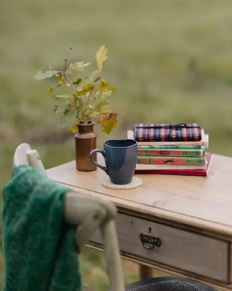 Pile of self-help coaching books on table in nature