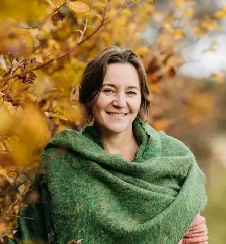 Karin Peeters smiling in front of autumnal tree