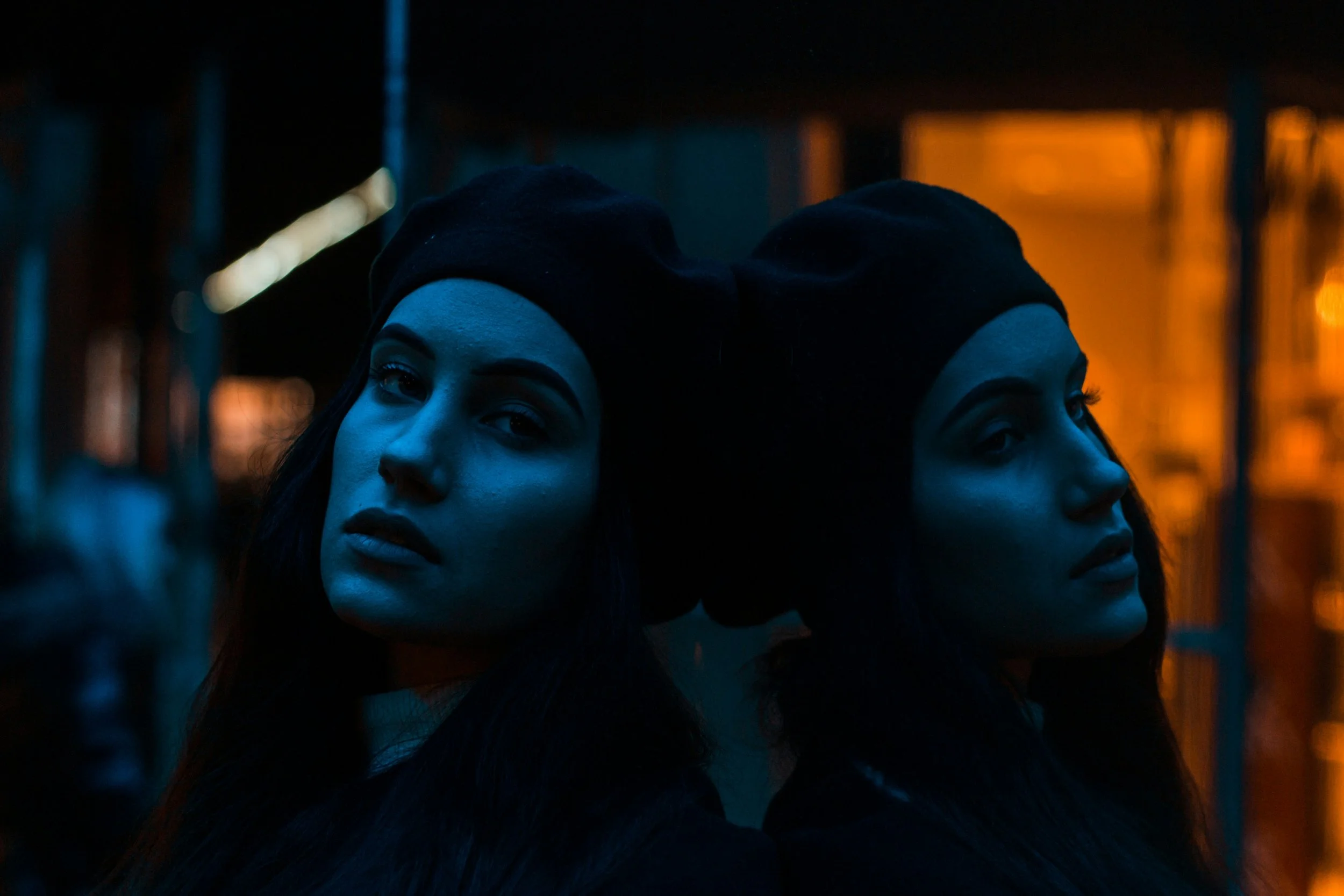 An image of two women. They're twins, but one looks like a shadowy version of the other.