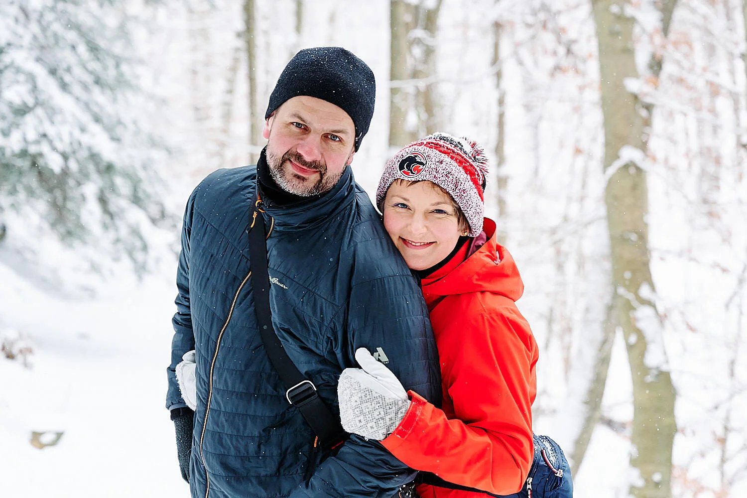  Family portrait on a hiking trail in Sewickley, Western Pennsylvania. Forest is covered with snow and the family is dressed in warm winter jackets, hats and gloves. They are playing snowballs balls and look happy. 