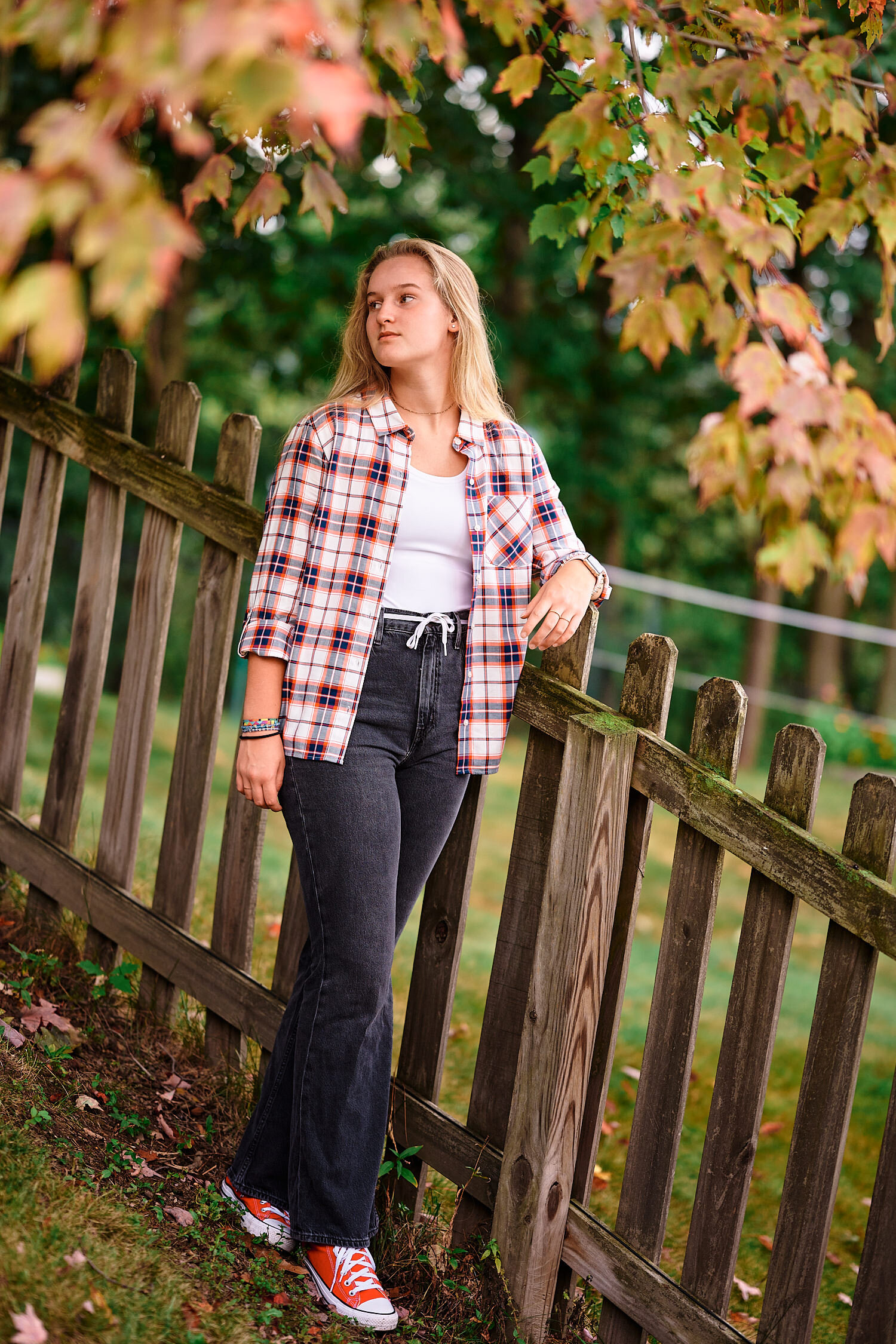  Alena is posing for a moody teenager photo series in her backyard on a rainy evening in Pittsburgh, Pennsylvania. She is dressed in her new checked shirt and flare jeans and looks cool and stylish. 