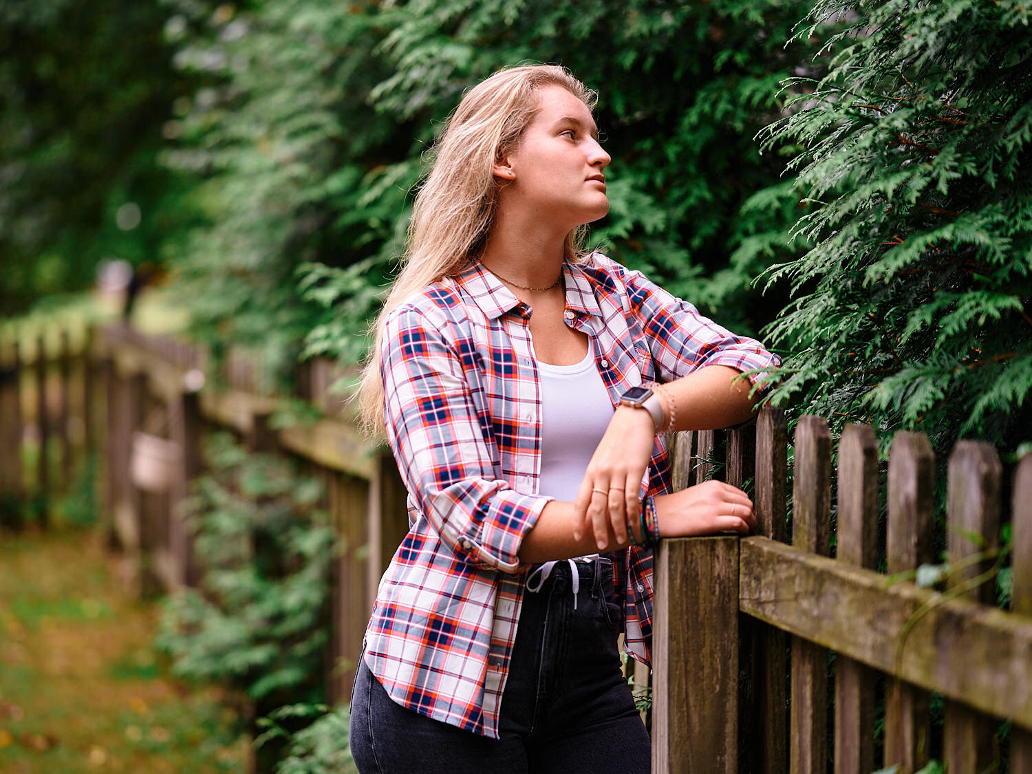  Alena is posing for a moody teenager photo series in her backyard on a rainy evening in Pittsburgh, Pennsylvania. She is dressed in her new checked shirt and flare jeans and looks cool and stylish. 