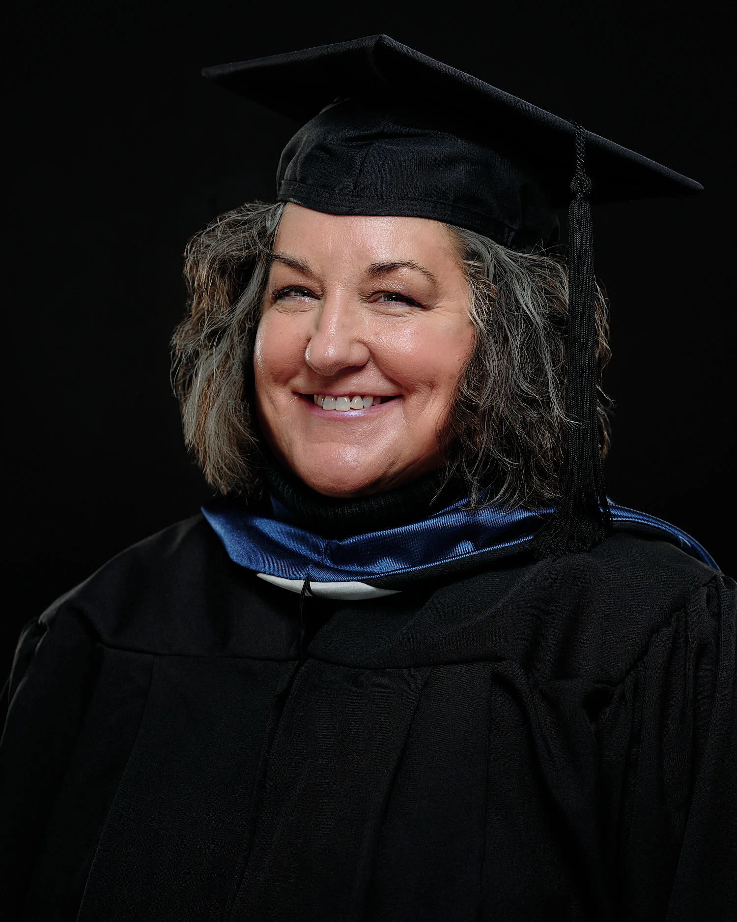  Teresa Phipps is posing for her University of Pittsburgh cap and gown portrait session. Teresa has fulfilled her father’s wish and is feeling emotional showing off the sapphire pendant he gave her. 