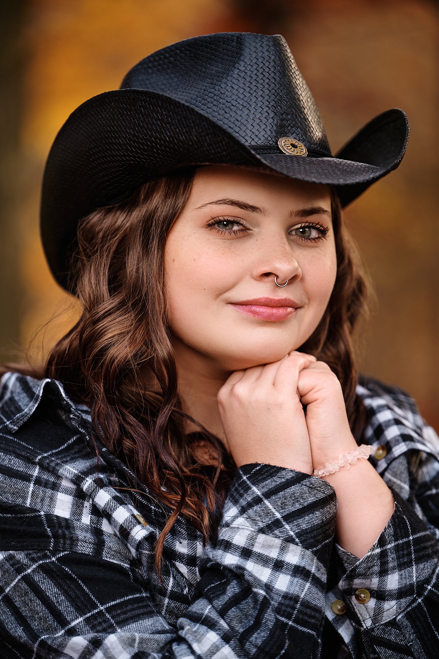 Heavyn Kerr is posing for high school senior portraits with a quarter horse in Hookstown PA. November fall foliage is at its peak with yellow and orange colors all around the beautiful teenage girl. 