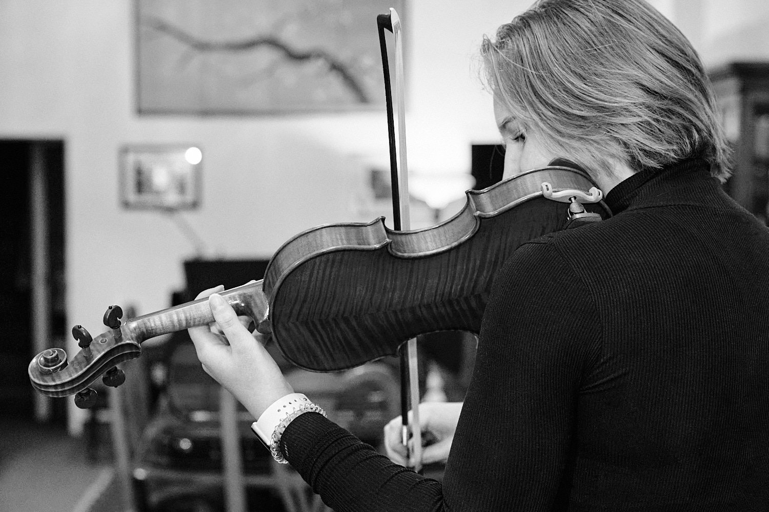  Alena Gurevich is testing new violins at Phillip Injeian Violin Shop in downtown Pittsburgh, Western Pennsylvania, USA. The musical instruments sound beautiful and clear and the girl looks happy 