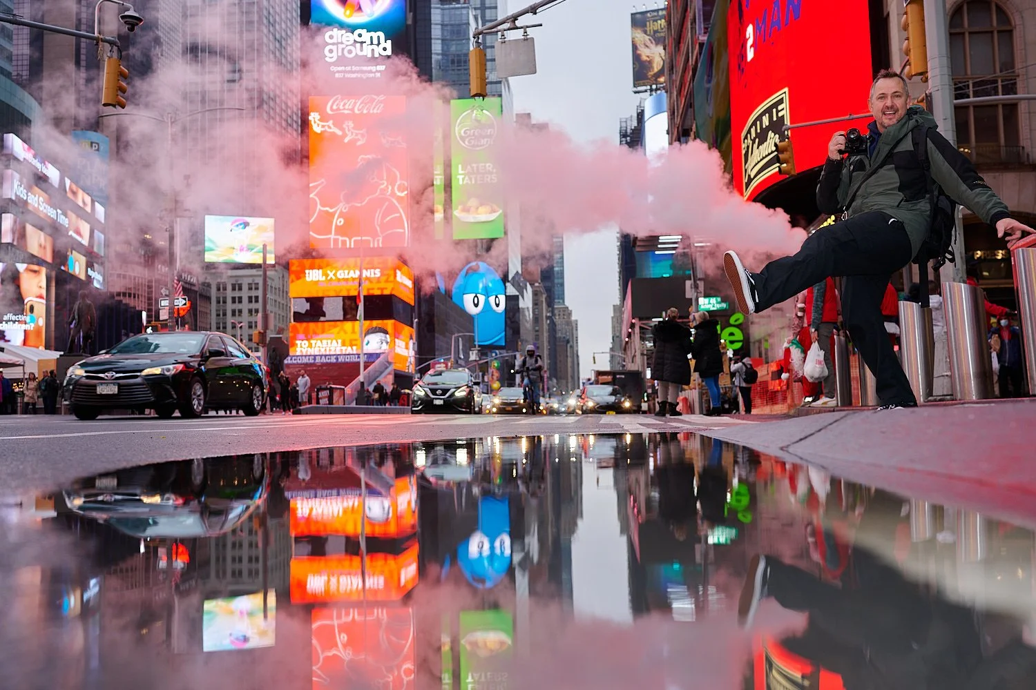  NEW YORK CITY, USA - DECEMBER 11TH 2021: Christmas mood at Times Square, Manhattan. It’s a foggy morning and the festive light, classic smoke and people passing by are reflected in the paddles. 