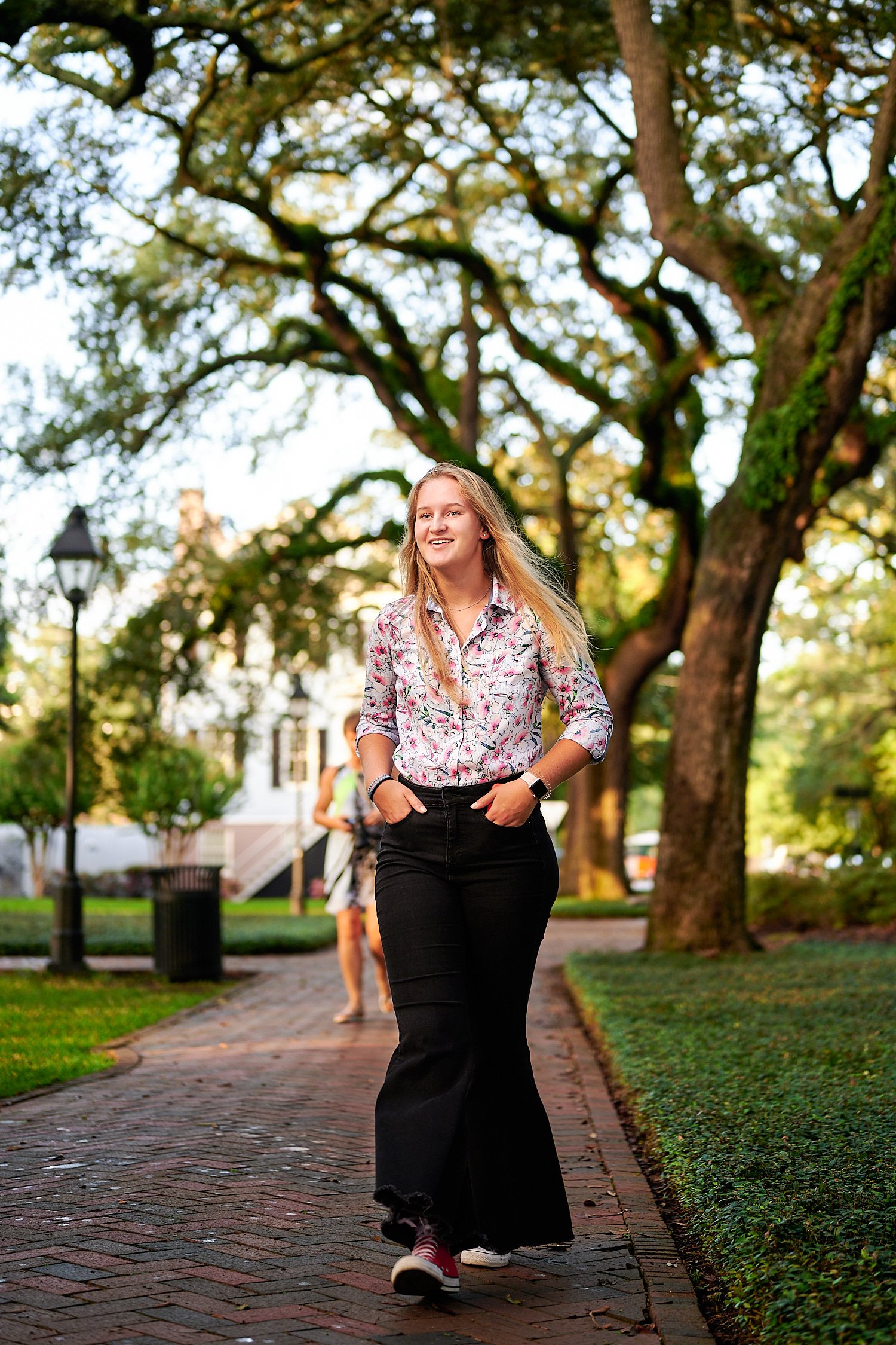  Savannah, Georgia, USA - OCTOBER 9TH 2021: a teenage girl is posing in the streets of Savannah on a warm autumn evening lit by the setting sun. The 16-year old had long blond hair and wore flare jeans 
