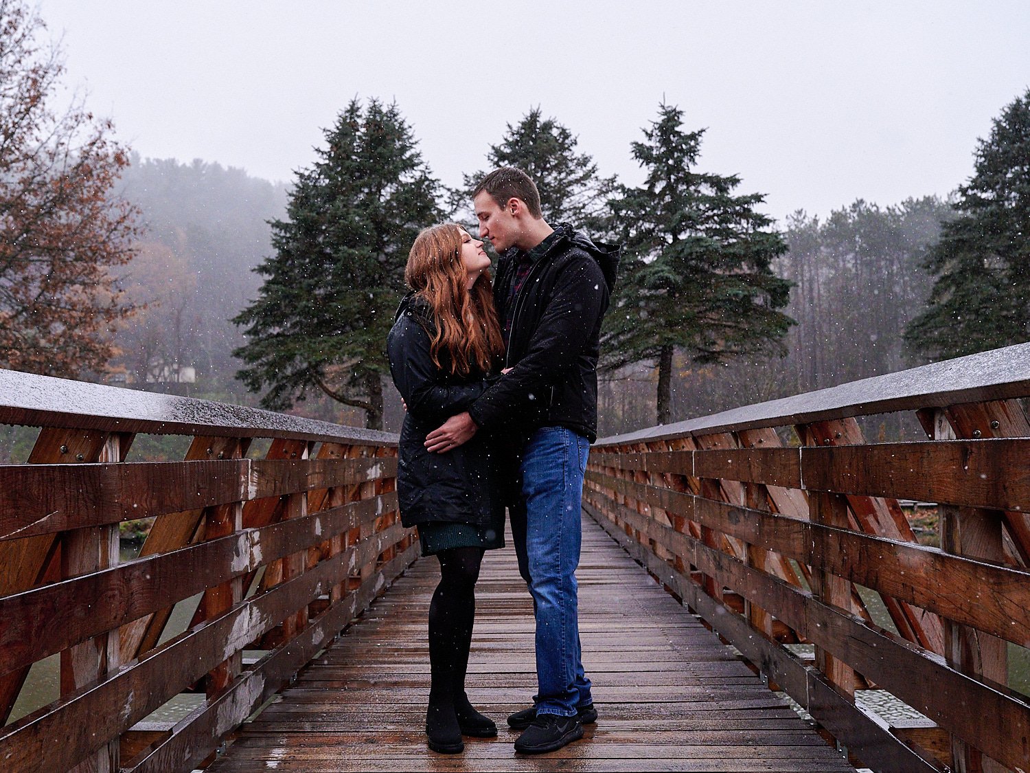  Victoria Detweiler is posing with her new husband on Marshall Island in North Park, Allegheny County near Pittsburgh, Pennsylvania. It’s very cold and it’s snowing. The trees around have few colors. 
