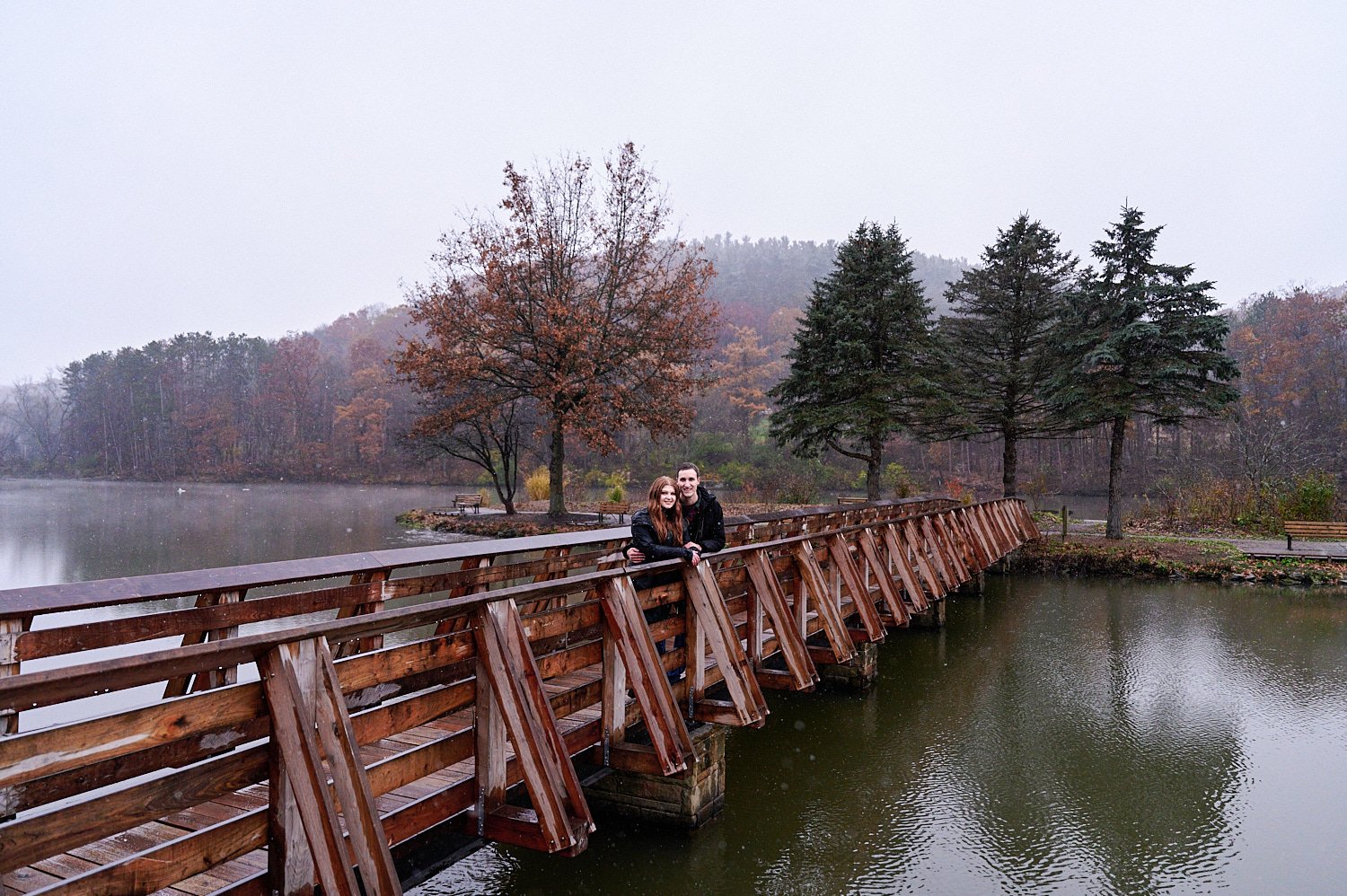  Victoria Detweiler is posing with her new husband on Marshall Island in North Park, Allegheny County near Pittsburgh, Pennsylvania. It’s very cold and it’s snowing. The trees around have few colors. 