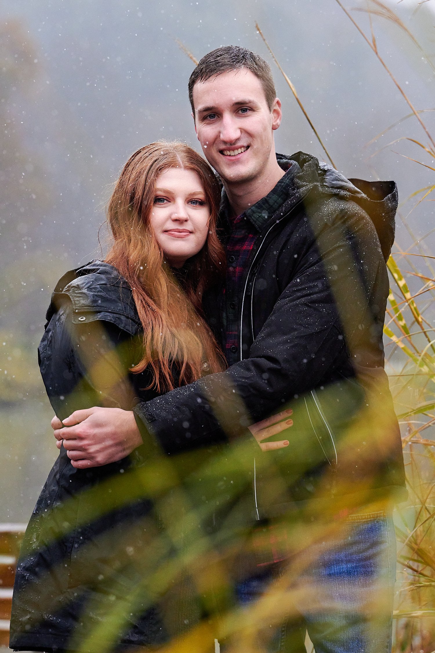  Victoria Detweiler is posing with her new husband on Marshall Island in North Park, Allegheny County near Pittsburgh, Pennsylvania. It’s very cold and it’s snowing. The trees around have few colors. 