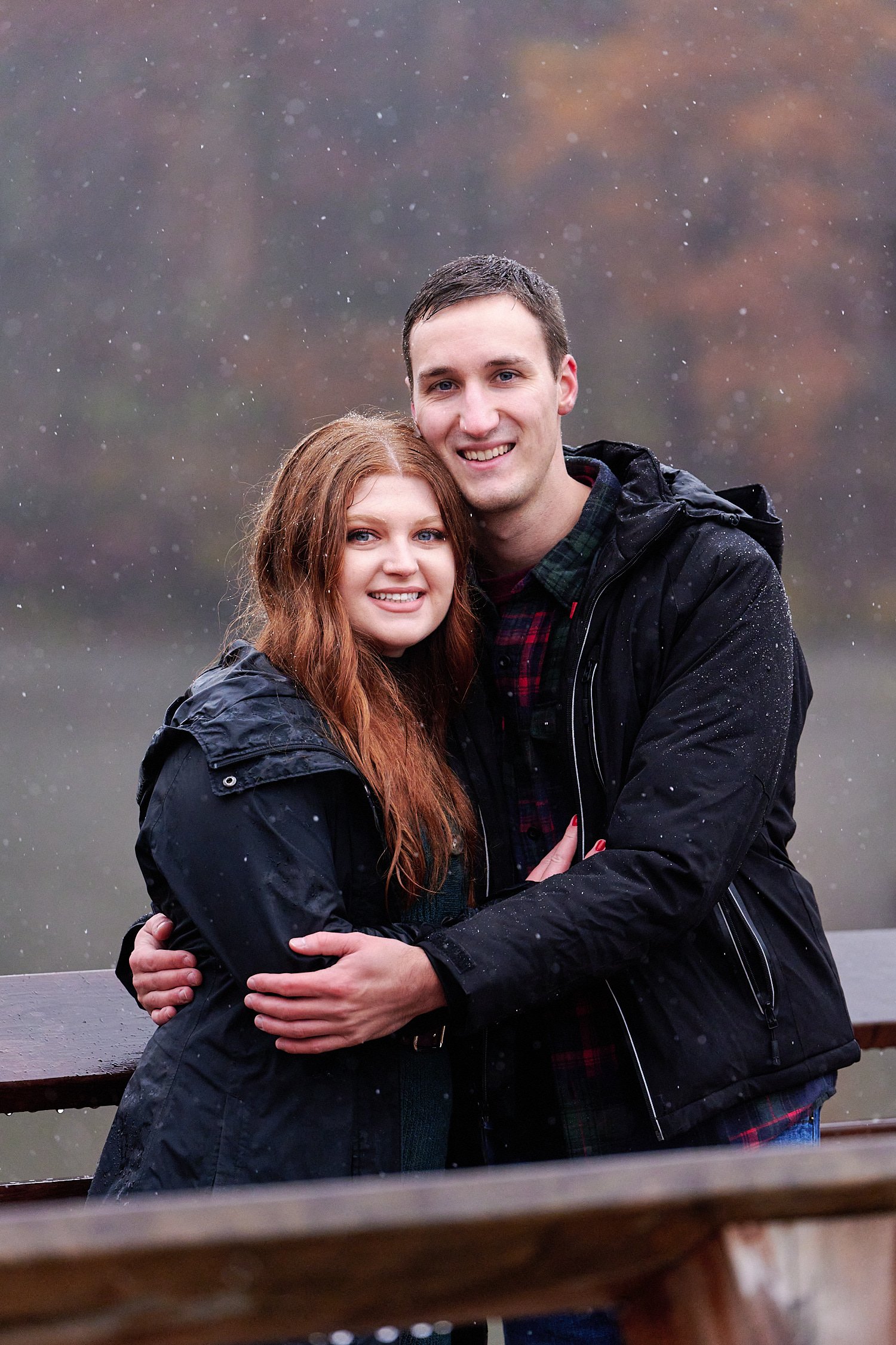  Victoria Detweiler is posing with her new husband on Marshall Island in North Park, Allegheny County near Pittsburgh, Pennsylvania. It’s very cold and it’s snowing. The trees around have few colors. 