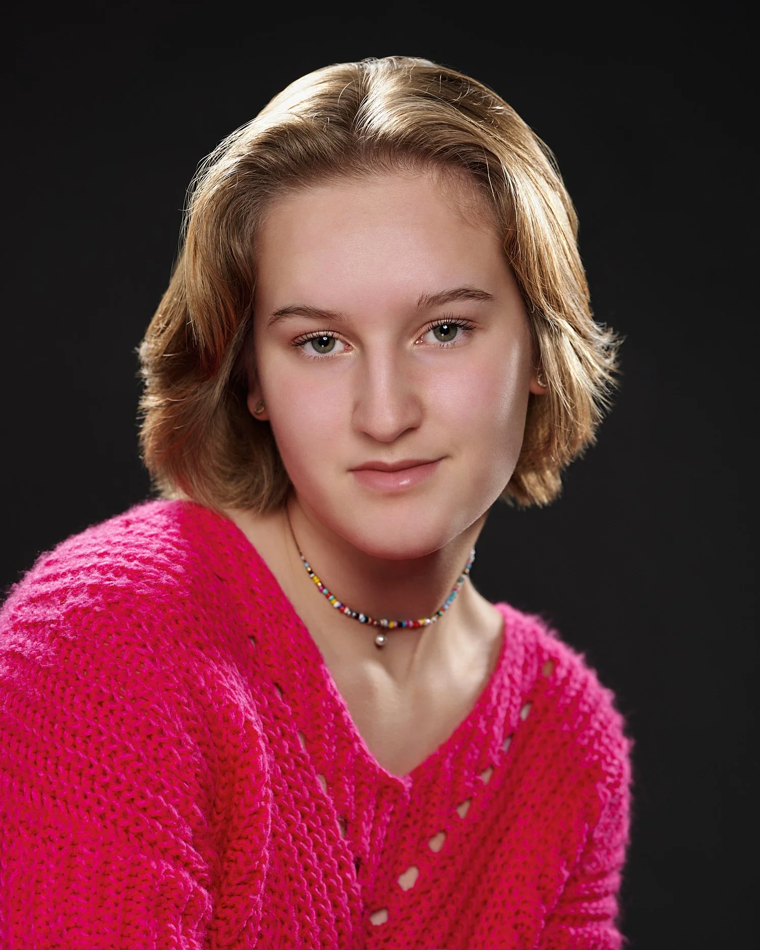  Alena Gurevich, a senior school student in Sewickley Academy, is posing for actor headshots for musical Urinetown showing on March 4-6th 2022. She has short blond hair and wears a pink sweater. 