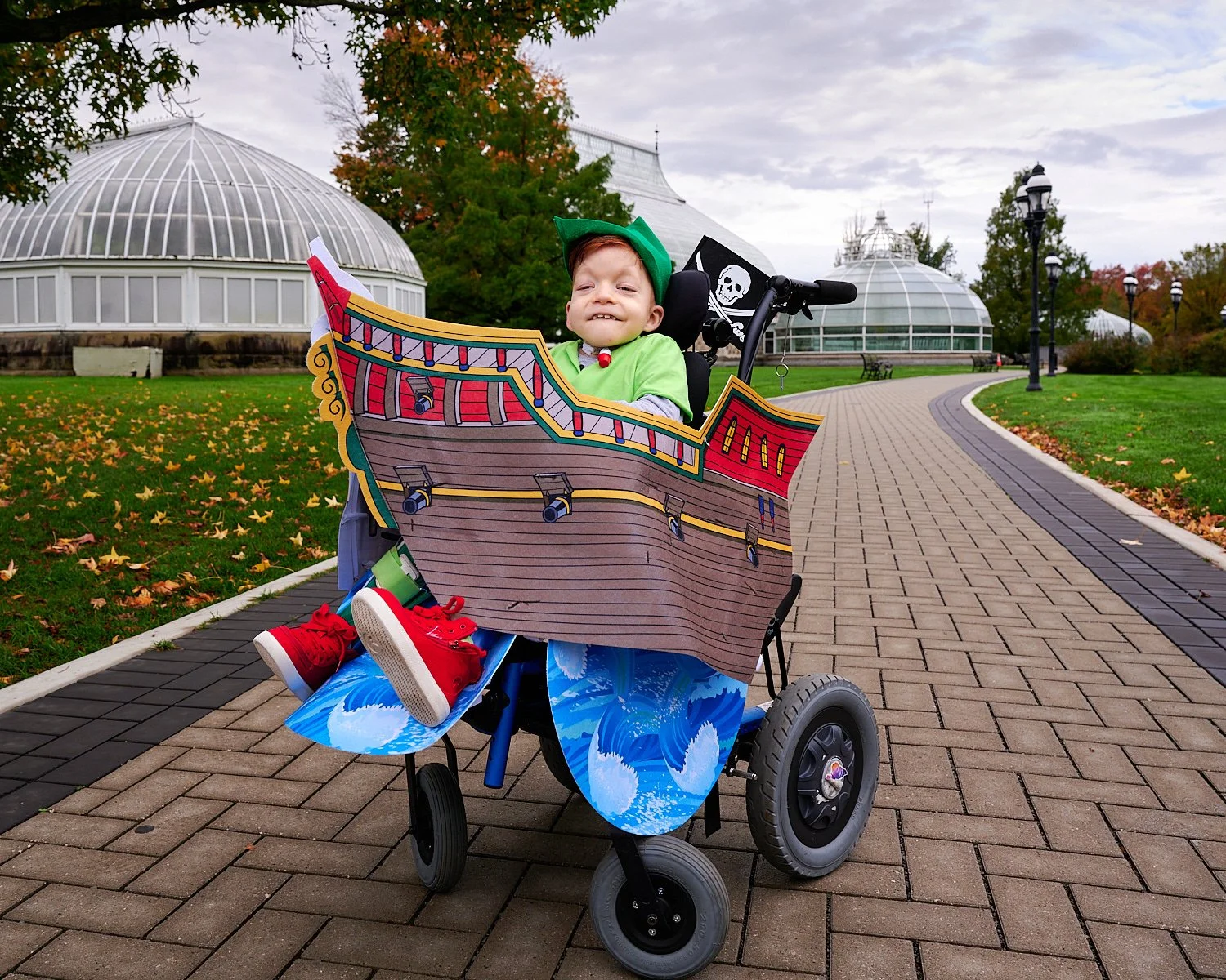 Michaela Robbins is posing with her husband, son and parents in front of Phipps Conservatory and Botanical Gardens of Pittsburgh, PA. The family is dressed in Peter Pan costumes - Tinker Bell, Pirate. 