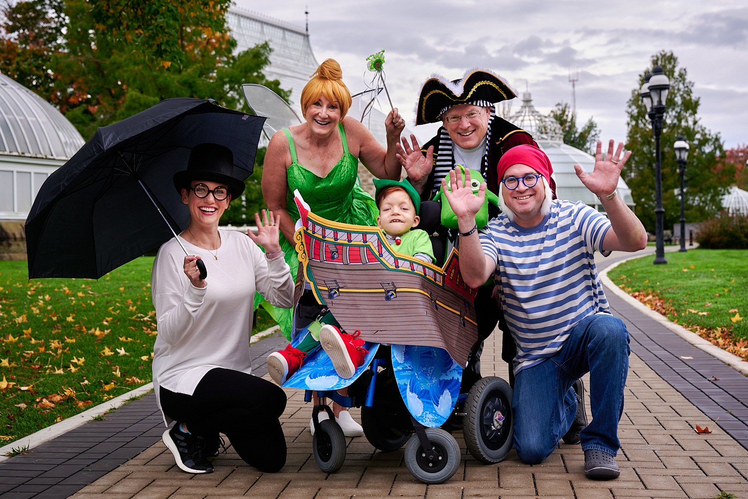  Michaela Robbins is posing with her husband, son and parents in front of Phipps Conservatory and Botanical Gardens of Pittsburgh, PA. The family is dressed in Peter Pan costumes - Tinker Bell, Pirate. 