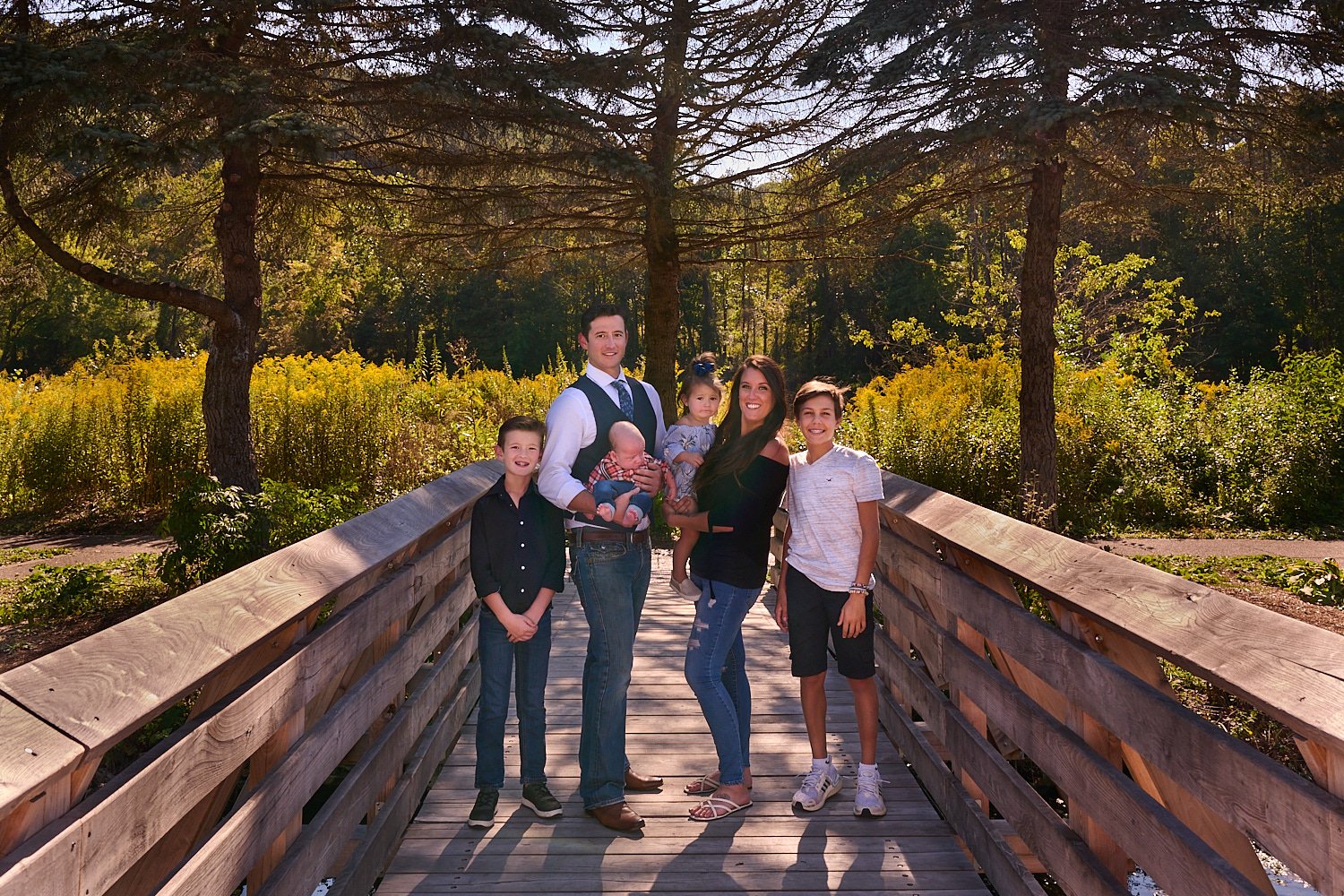  Kelly Larmann is posing for family portraits with her husband and four children aged from a newborn baby boy to a toddler girl and two middle-schooler sons. The daughter was exceptionally agile. 