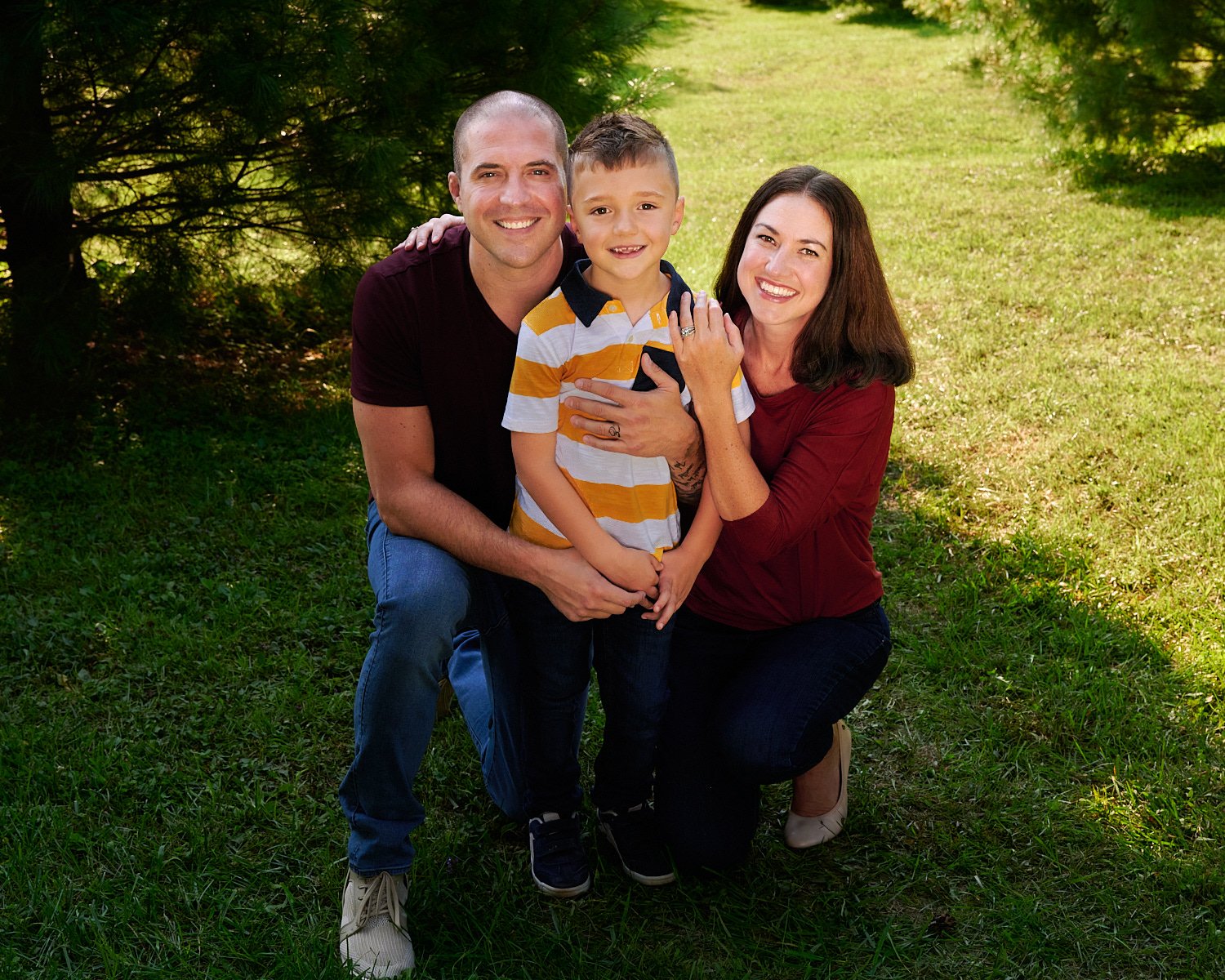  Erin Greiner is posing for formal and candid family photos with her husband and six-year-old son. The Cranberry community park has a pond and pine trees for Christmas-style and summer themed portraits 