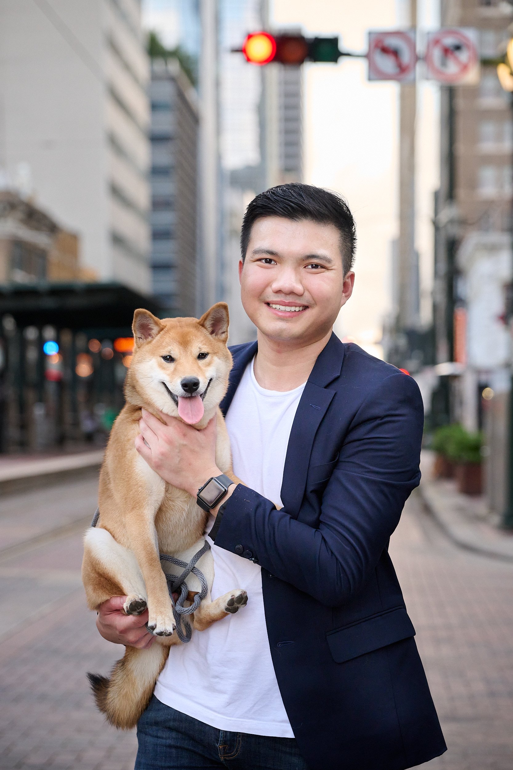  HOUSTON, TEXAS - AUGUST 27TH 2022: Yosa Puspo is posing in a suit with his dog for fun and memorable portraits in Downtown Houston. Market Square, Main Street and cityscape are perfect backgrounds. 
