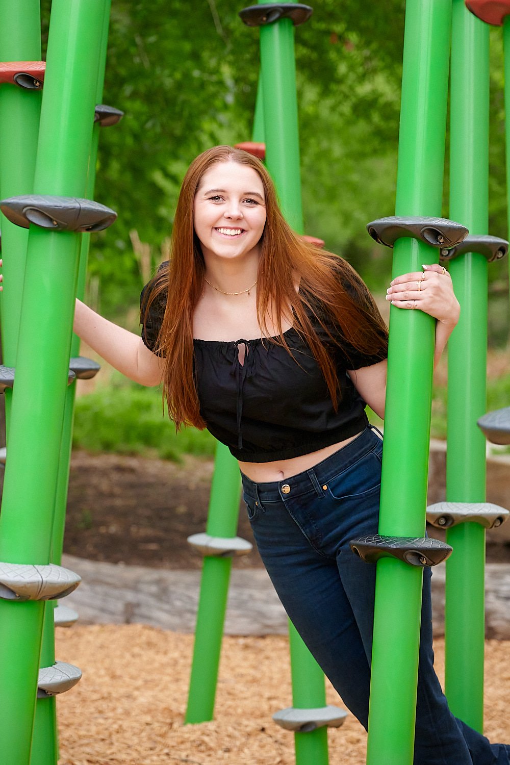  HOUSTON, TEXAS - MARCH 2023: Jillin Asbill, a pretty 17-year-old red-haired and round-faced girl in a black cropped top and navy blue jeans is posing for high school senior portraits for a yearbook. 