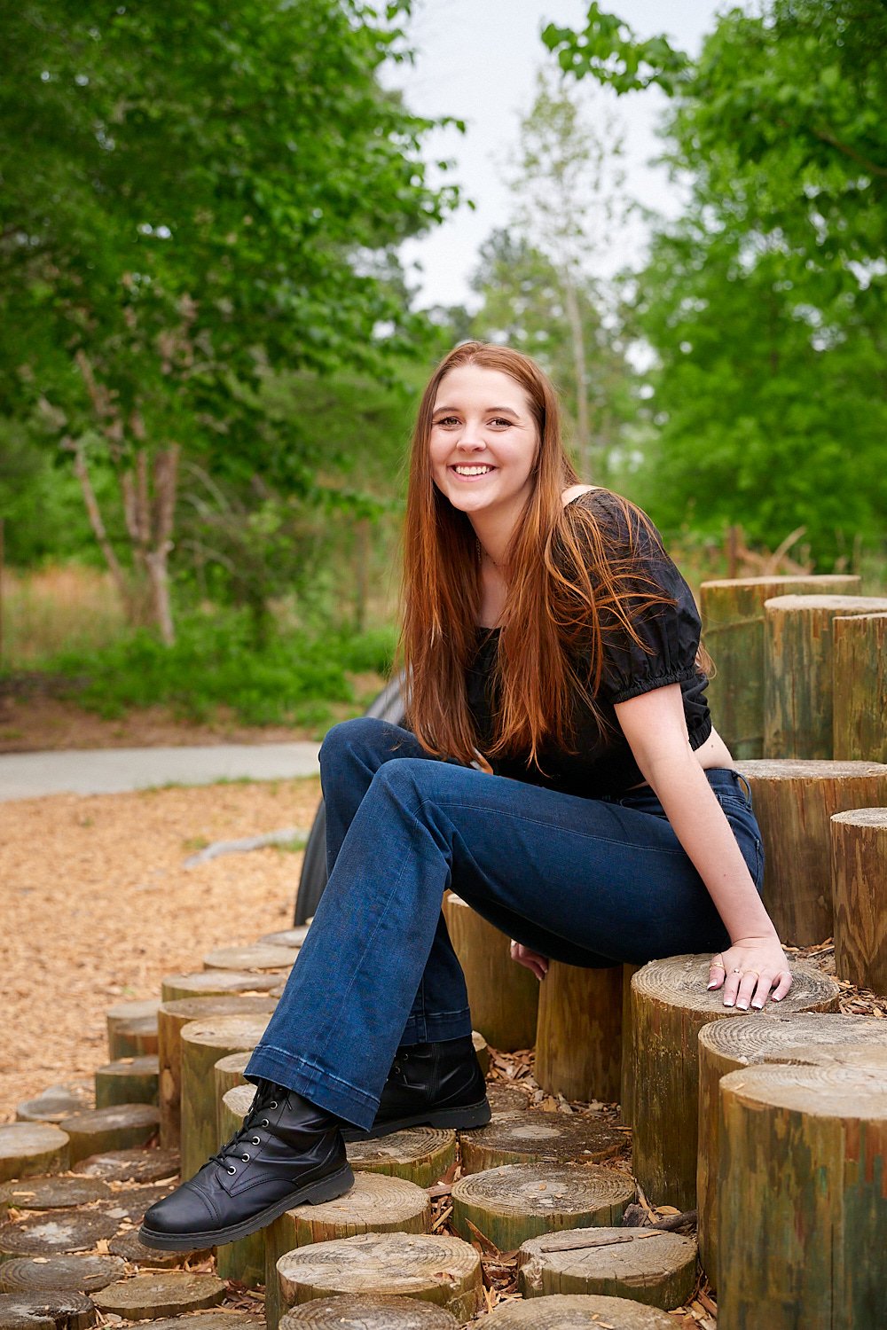  HOUSTON, TEXAS - MARCH 2023: Jillin Asbill, a pretty 17-year-old red-haired and round-faced girl in a black cropped top and navy blue jeans is posing for high school senior portraits for a yearbook. 