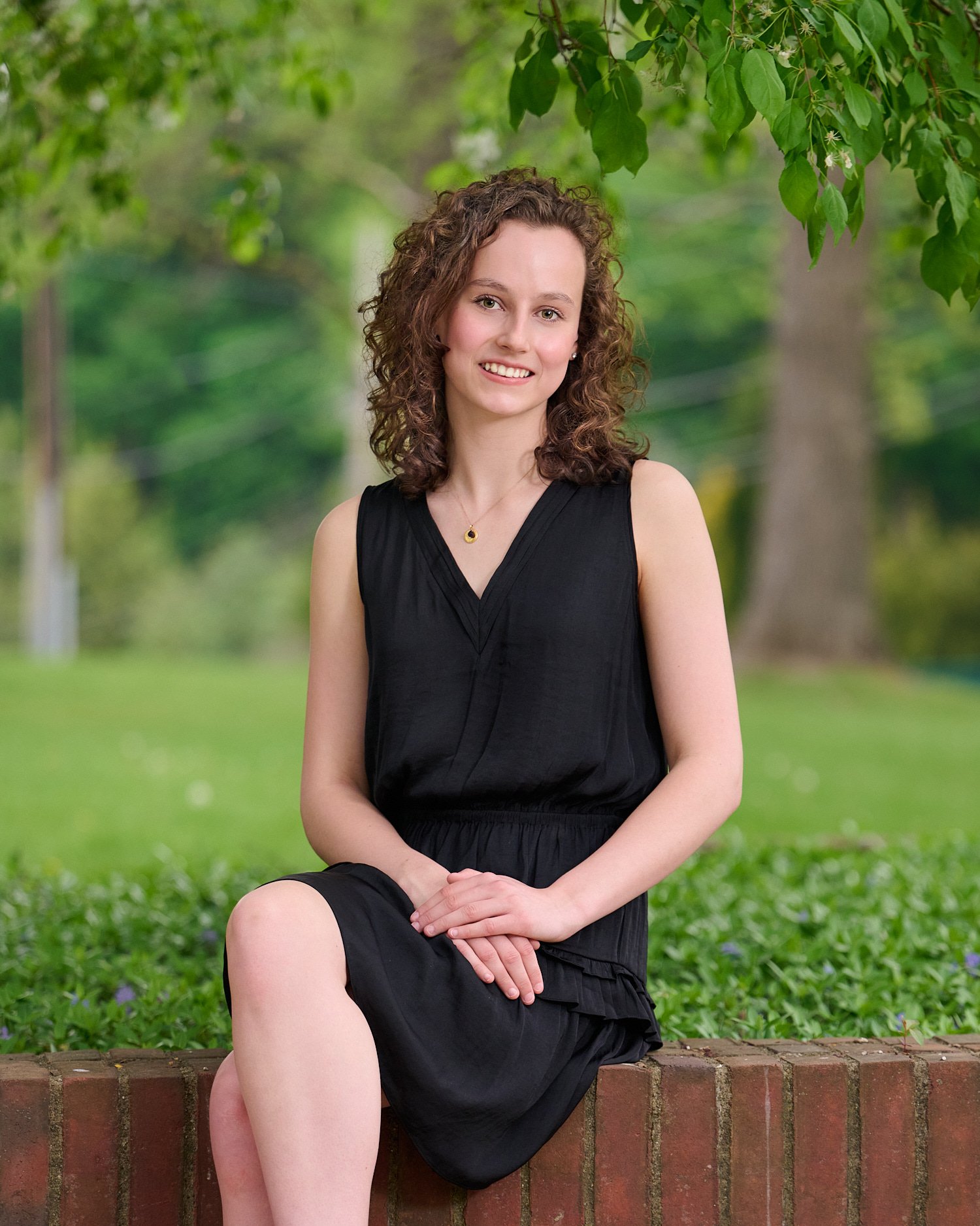  Rebecca Glass is posing for her high school senior portraits with beautiful spring flowers and water as she is an avid swimmer. Class of 2022, Sewickley Academy, Pittsburgh, Pennsylvania, USA. 