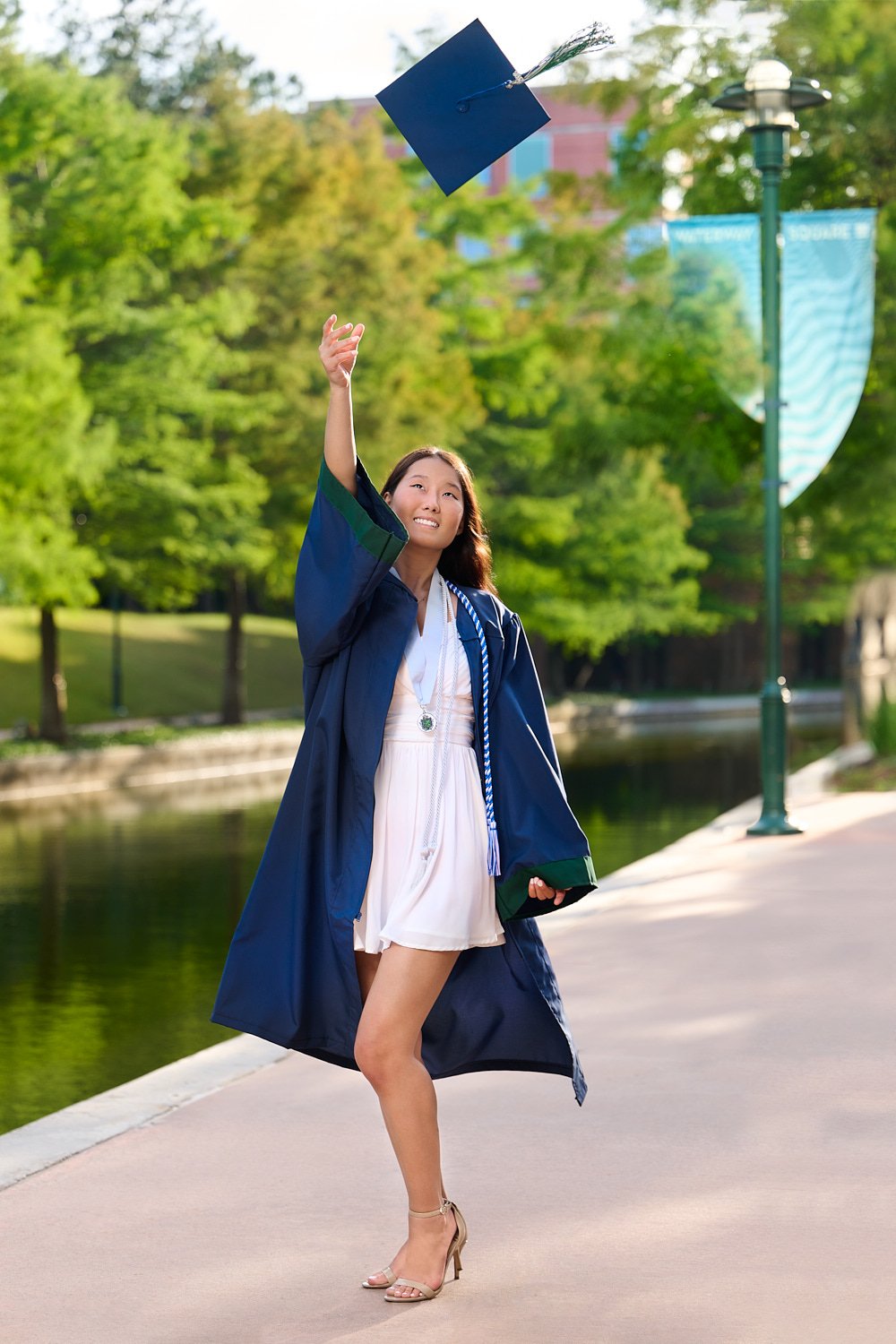  THE WOODLANDS, TEXAS - MAY 20th 2023:  pretty girl Nuray Demessinova is photographed in navy blue graduation cap and gown, celebrating finishing The Woodlands College Park School, Texas class of 2023 