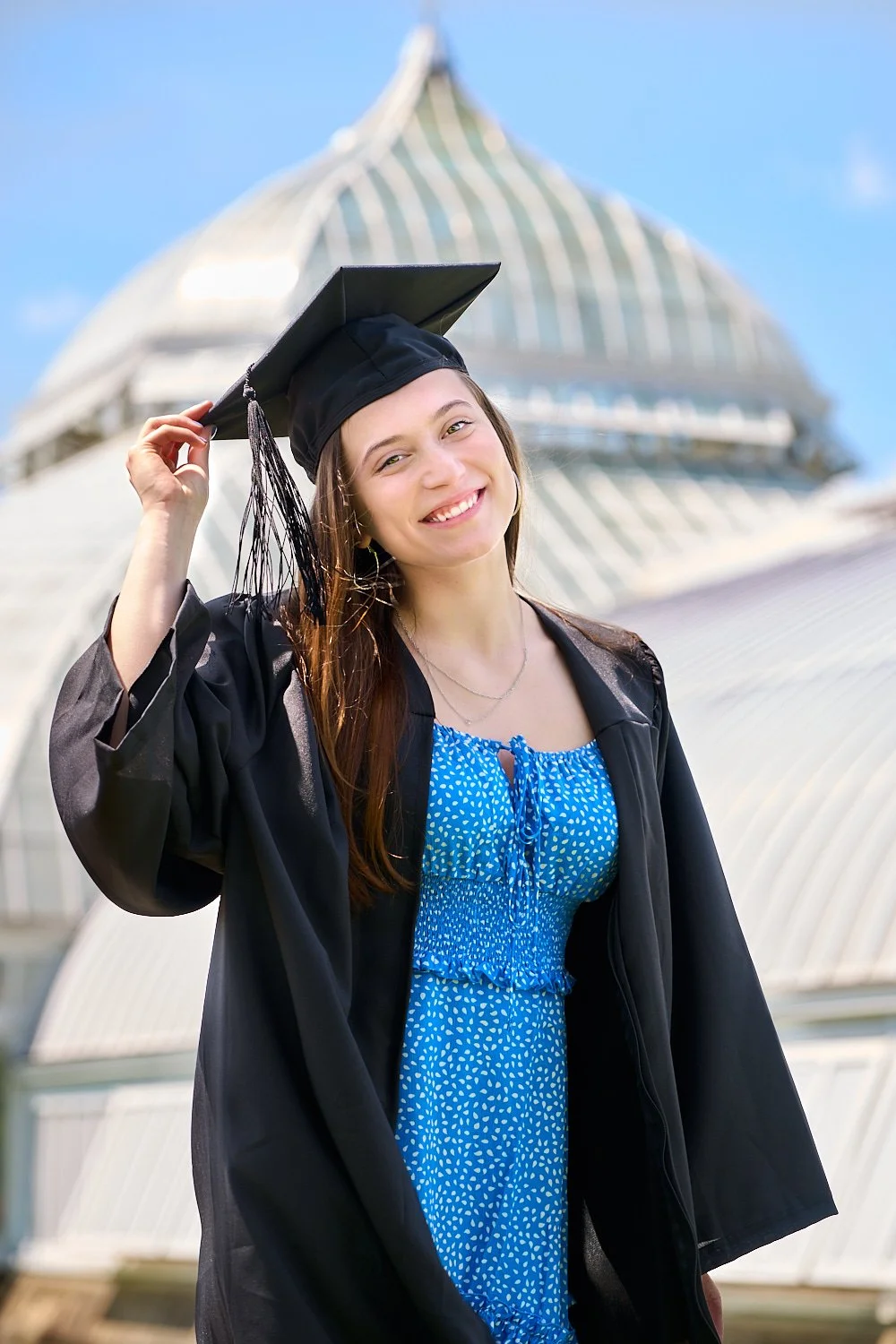  THE WOODLANDS, TEXAS - MAY 24th 2023: The Woodlands High School graduate Megan Testa is posing for her graduation portraits in black cap and gown outfit against blue skies of Texas. Texas A&M 2023. 