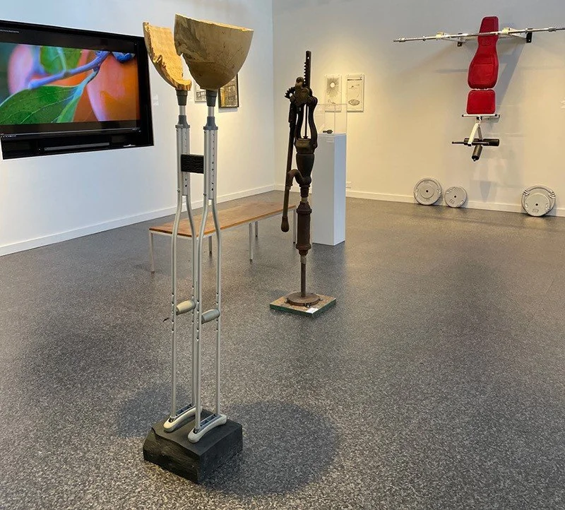 Jean-François Delorme "Broken" (foreground);
Rack-and-Pinion water pump courtesy of The Mercer Museum (middle ground);
Frederick Fisher and Partners "Ojai Valley School" (video on monitor);
Kristen Neville Taylor "Workers Wake Up"  and "End of Days"