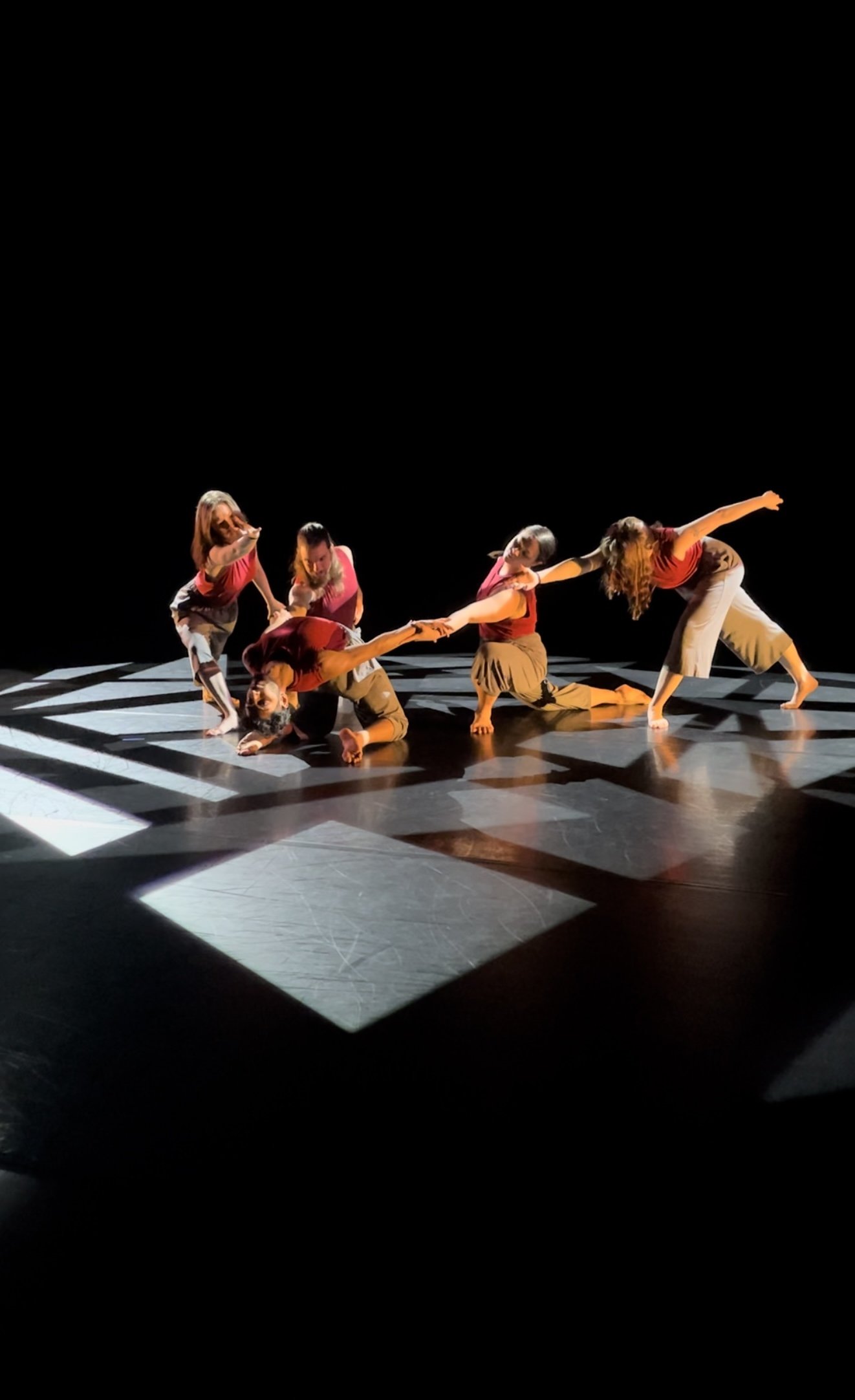 Four dancers on stage in arrow shape