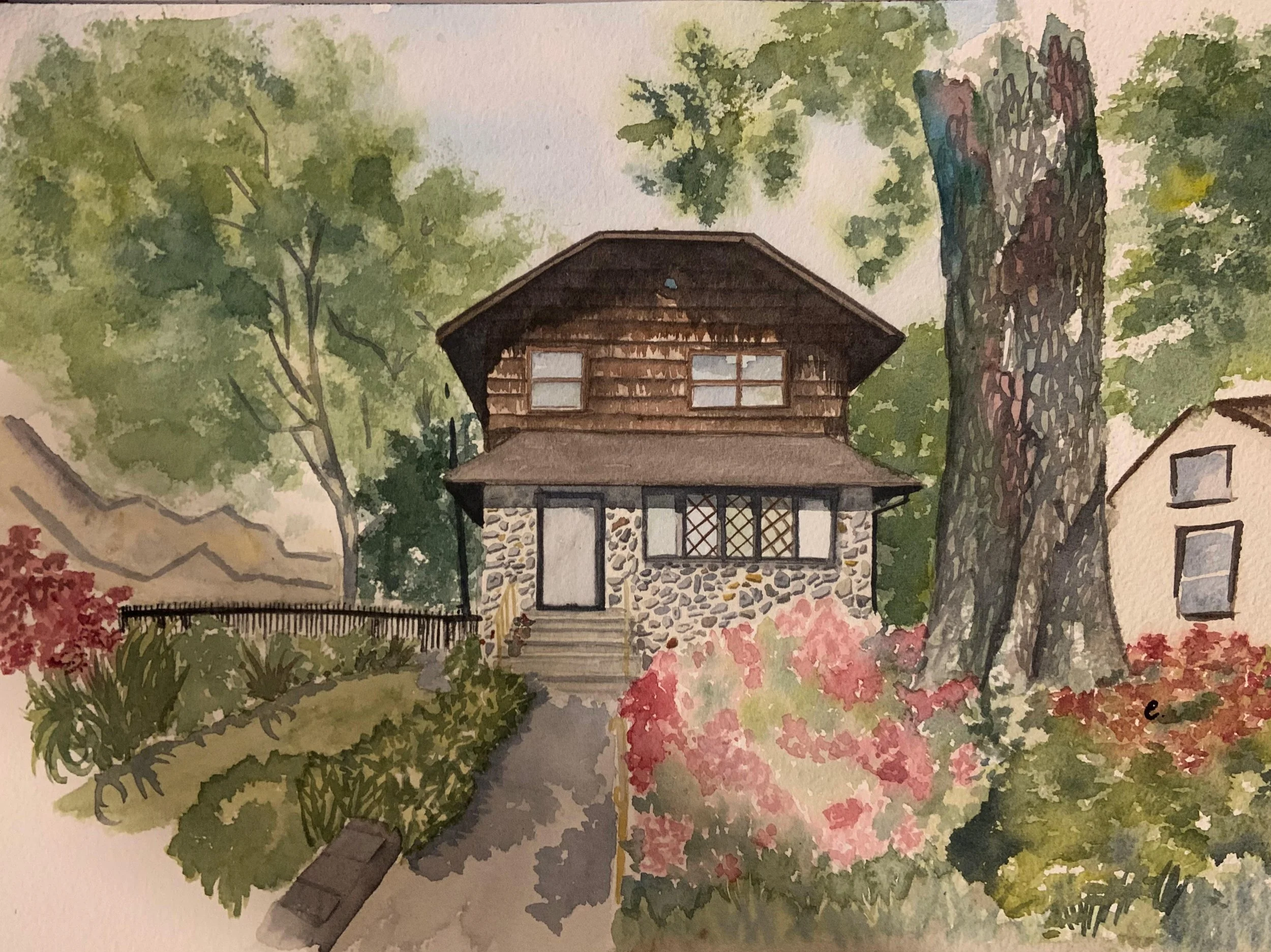 Watercolor painting of a two-story house with a stone base and wooden upper level, surrounded by trees and colorful bushes, with a pathway leading to the front door.