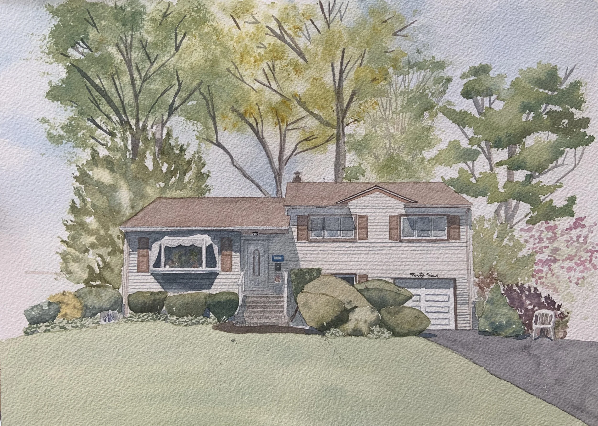 Watercolor painting of a two-story house with a front yard featuring bushes and rocks, tall trees in the background, and a driveway leading to a garage.