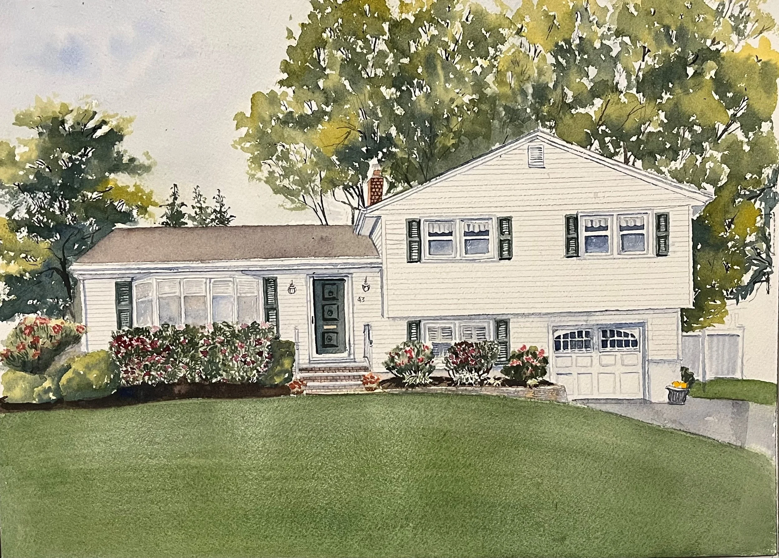 Watercolor painting of a suburban house with white siding, black shutters, and a front porch with steps. The house has a two-car garage, colorful bushes and flowers in the front yard, and tall trees behind it. The lawn is green and well-kept.