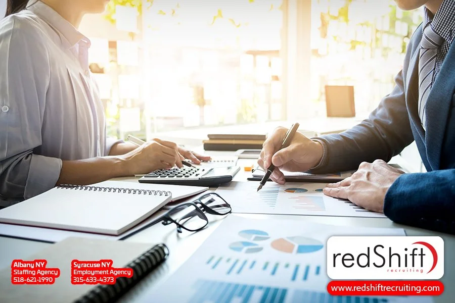 High-angle view of business professionals collaborating and working on an iPad, emphasizing digital collaboration in a modern office setting.