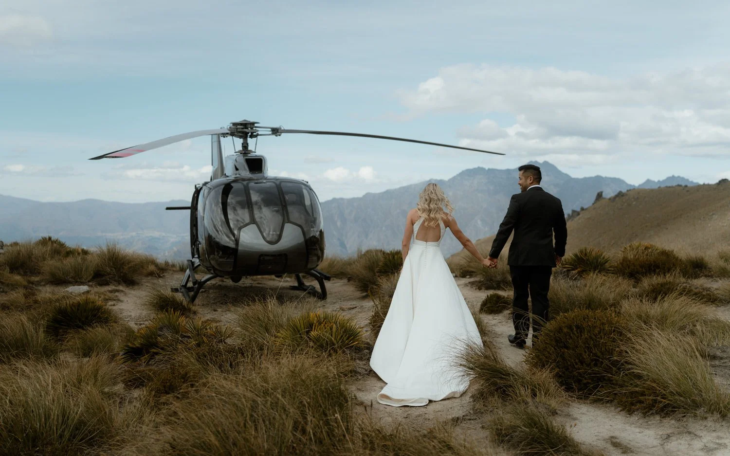 Bride and Groom walking to the helicopter Cecil Peak elopement