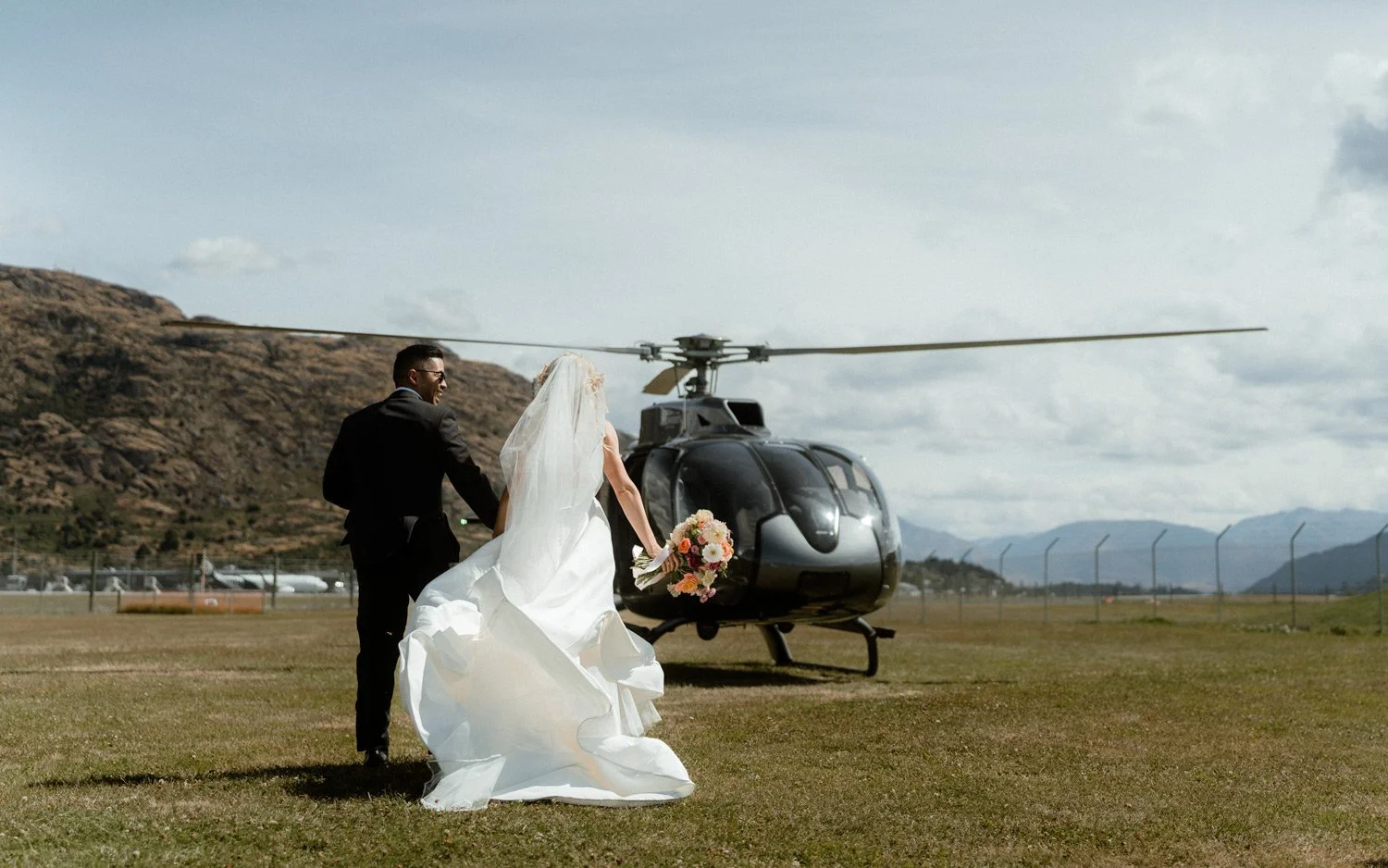 bride and groom walking to helicopter for their heli wedding in queenstown