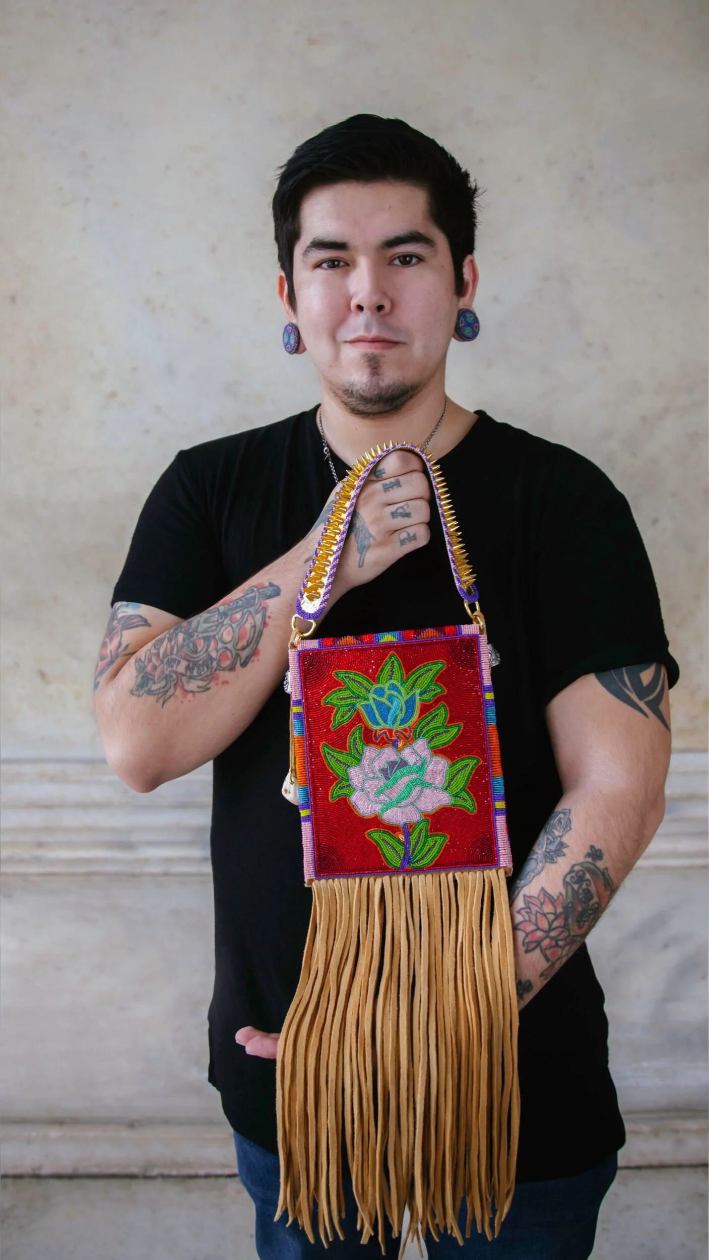 Photo of me Elias Not Afraid, holding my beaded bag for the Field museums exhibition: Apsaalooke women and warriors 2020-2023