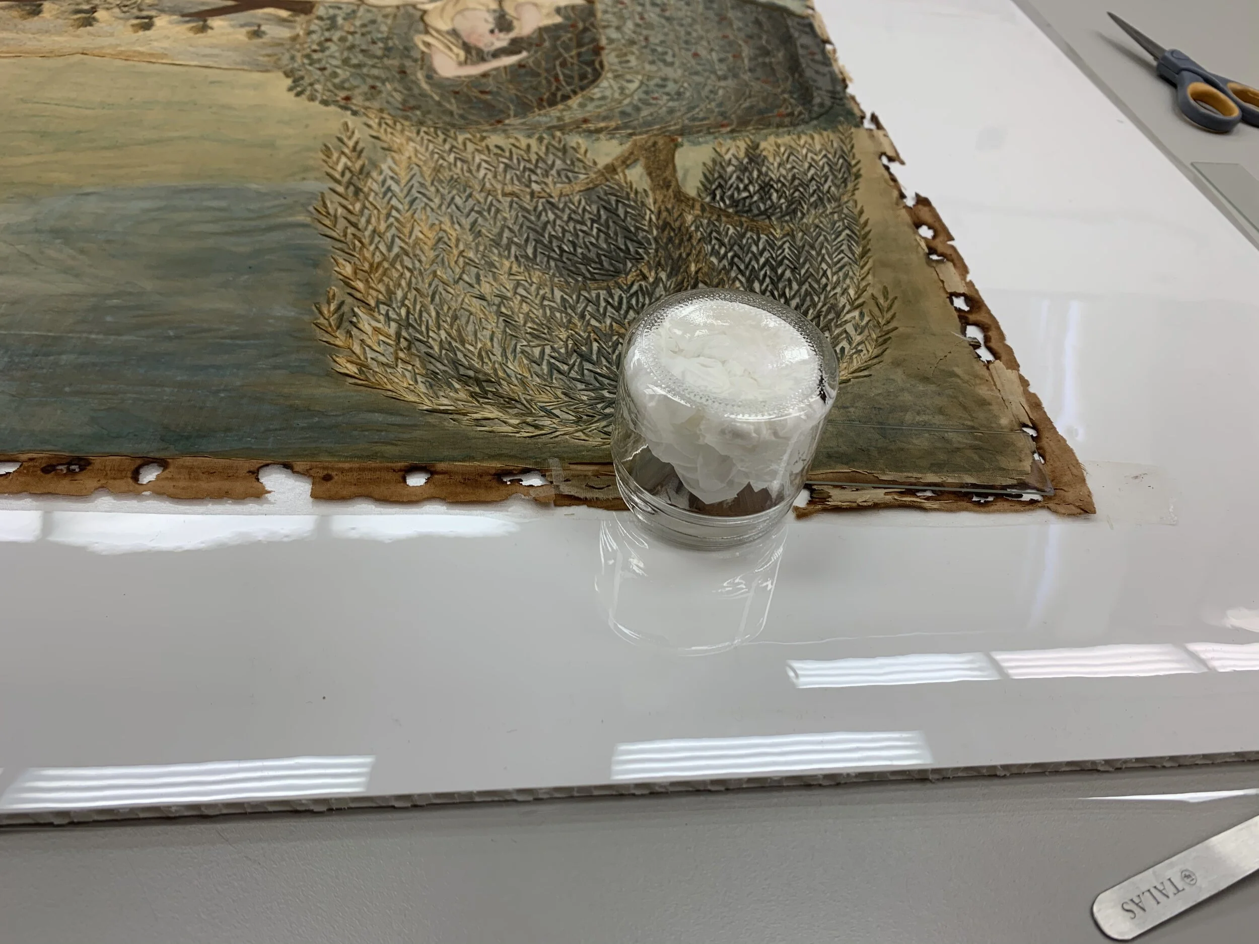 7. The edges of the cotton support were lined with crepeline coated in 1:1 Lascaux 360HV: 498HV. It was reactivated using an ethanol vapor chamber.