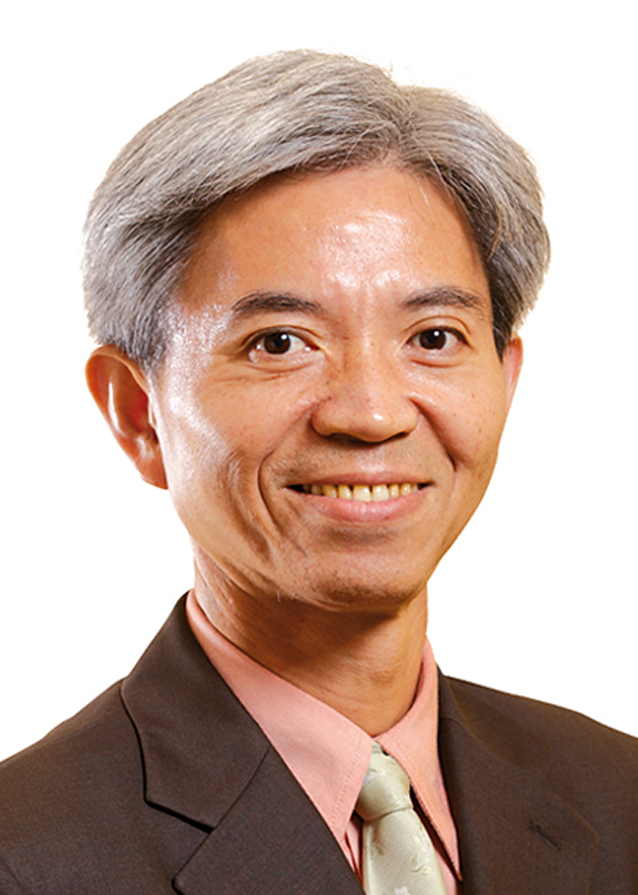 Head & shoulders image of Timothy smiling at the camera. He has dark and grey hair and is wearing a dark grey suit jacket and a salmon coloured shirt.