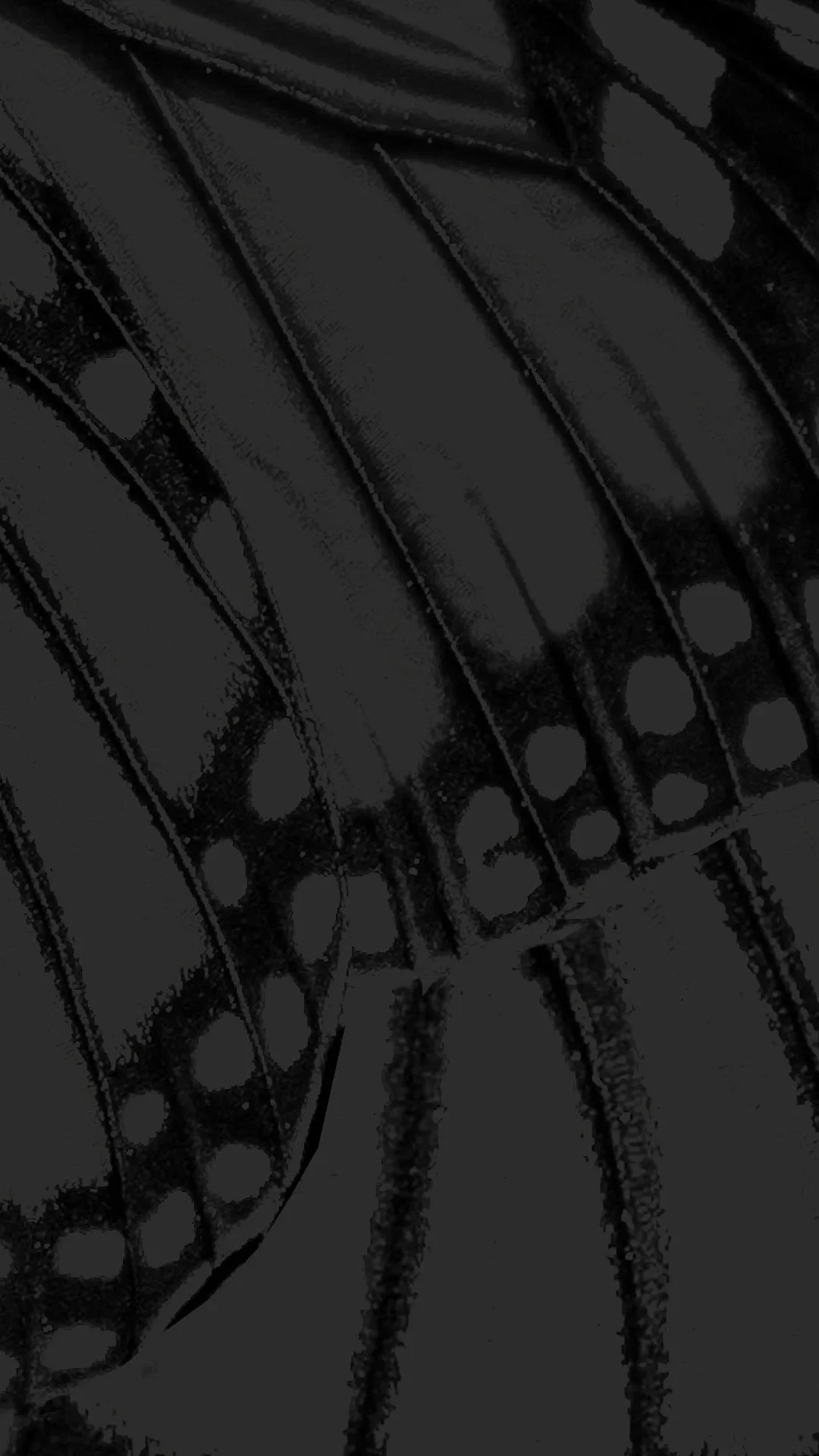 Close-up of several black leather belts stacked together.