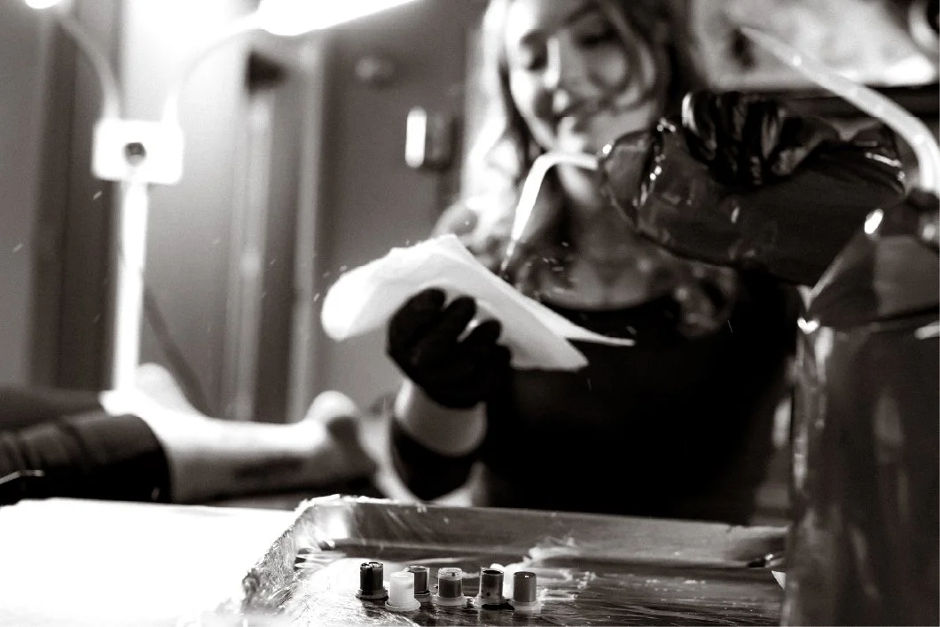 A nurse wearing gloves holding a paper under oxygen tubing at a hospital bedside.