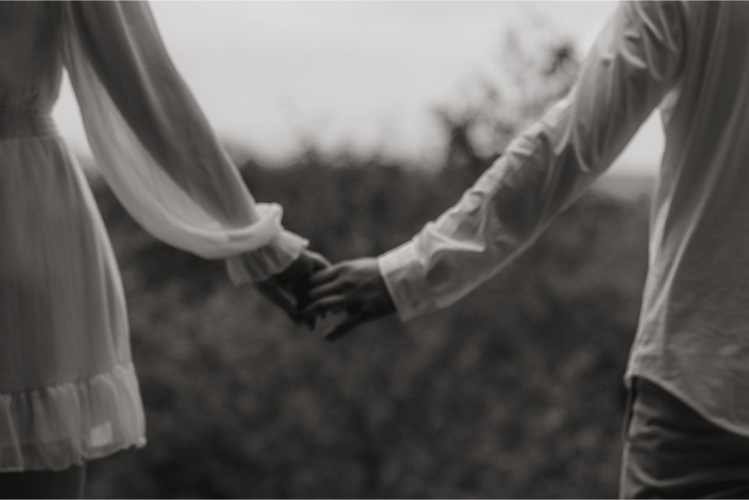 Two people holding hands outdoors during daytime