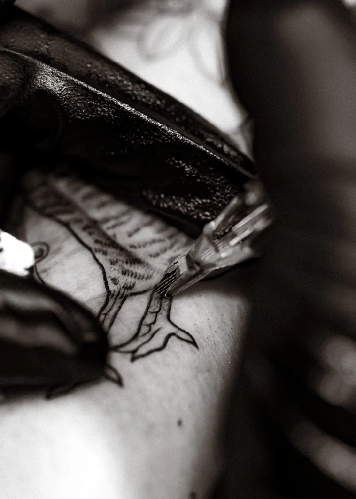 Close-up of a tattooed arm with a black leather belt and a partially opened snack bag, showing part of the snack inside.