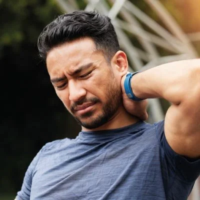 man clutching his neck with pain