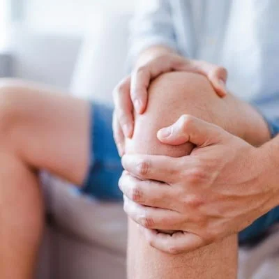 man clutching his knee with pain