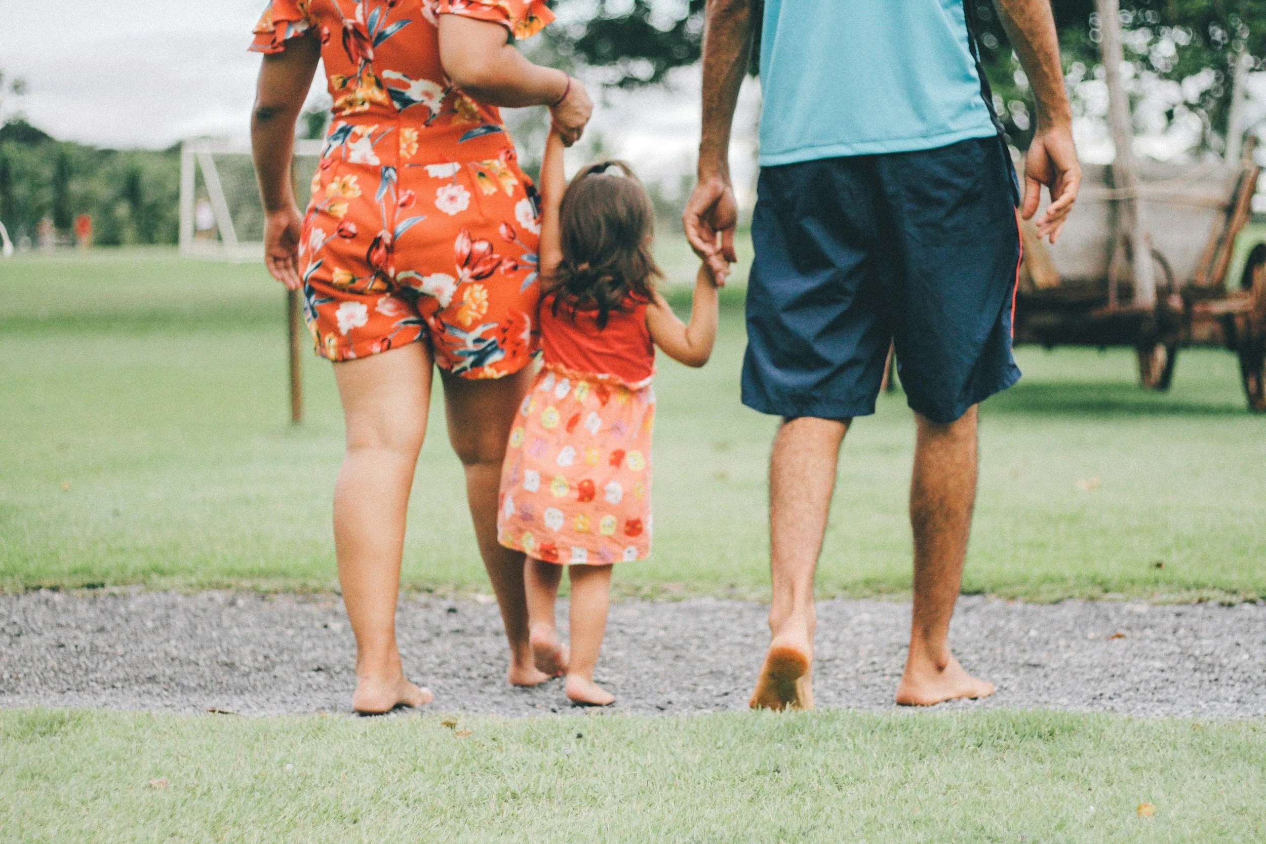 Young family holding hands with their toddler