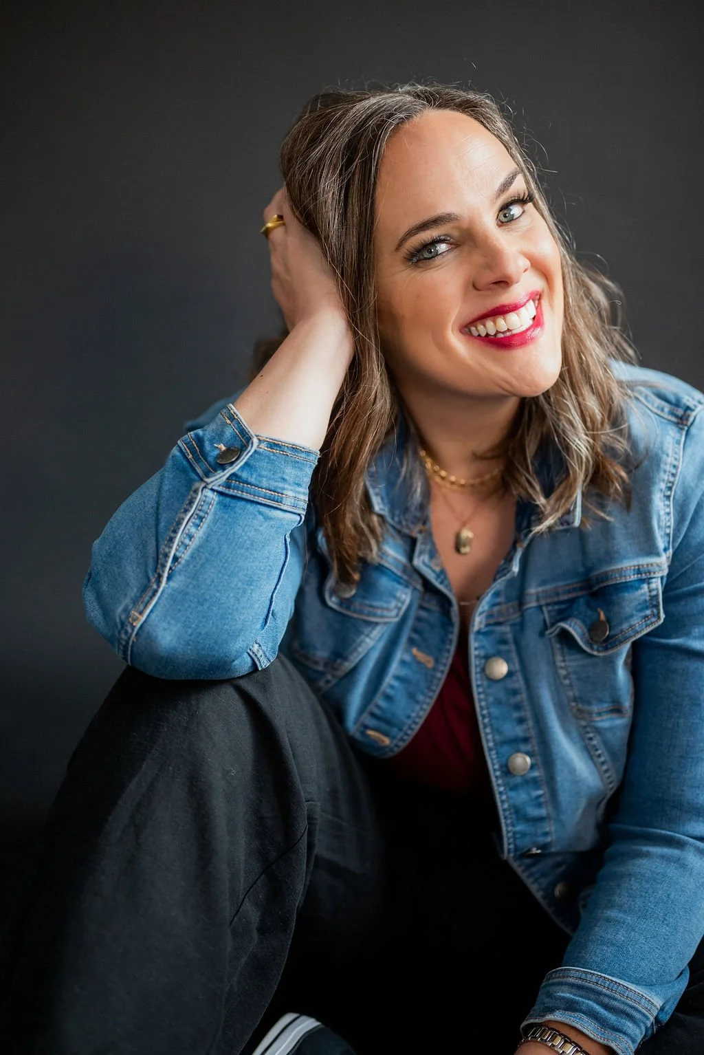 About Cara Chace, Speaking and Press Page Introduction wearing a denim jacket and smiling