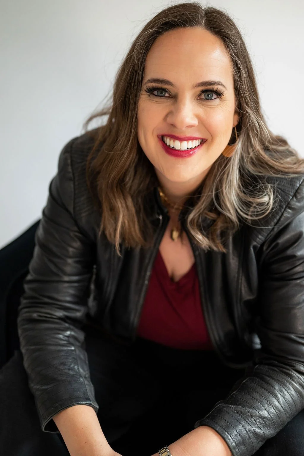 Cara Chace, author and burnout coach, smiling in a black leather jacket