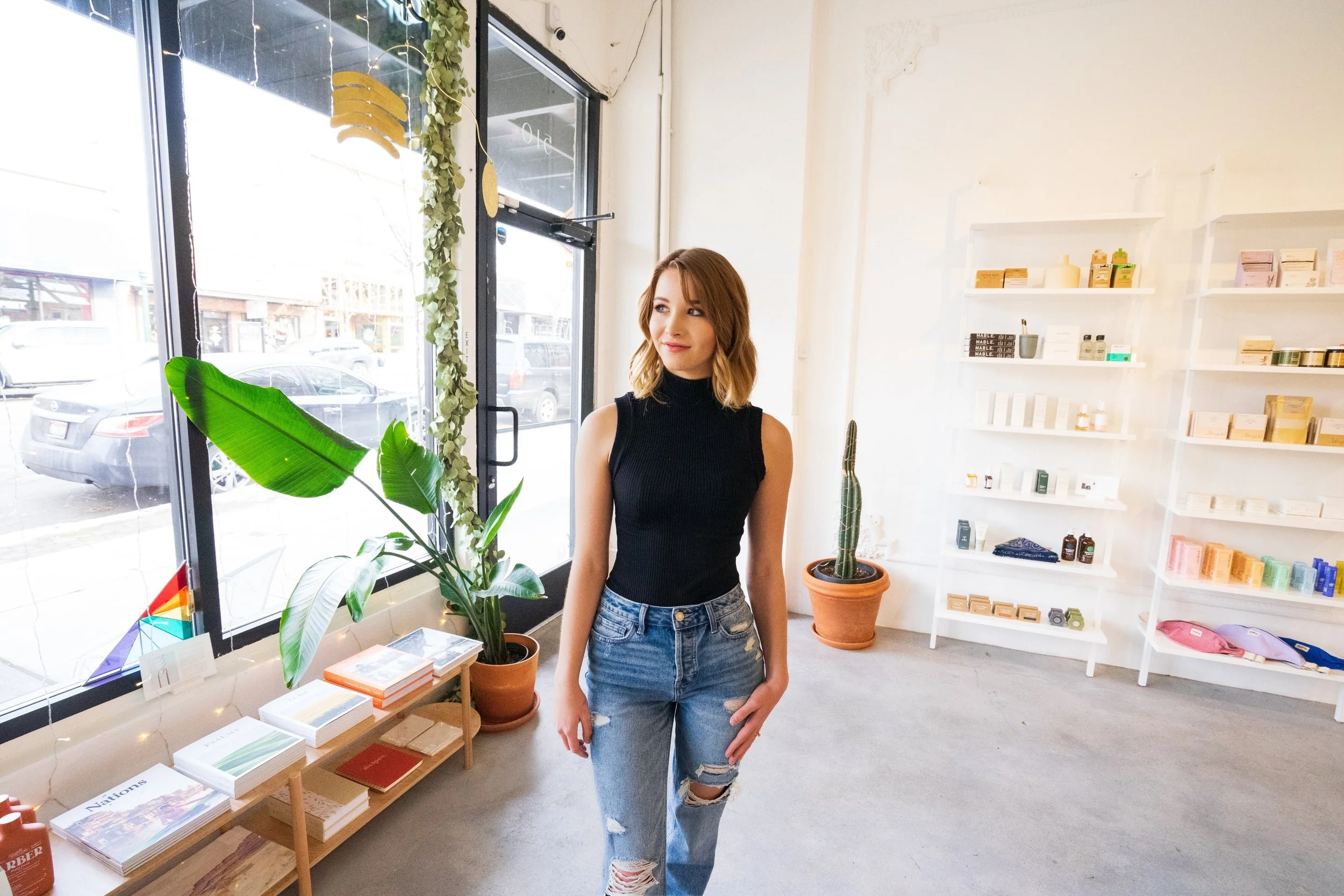 A young woman with long blonde hair, smiling, wearing a white blouse and red blazer against a plain white background.